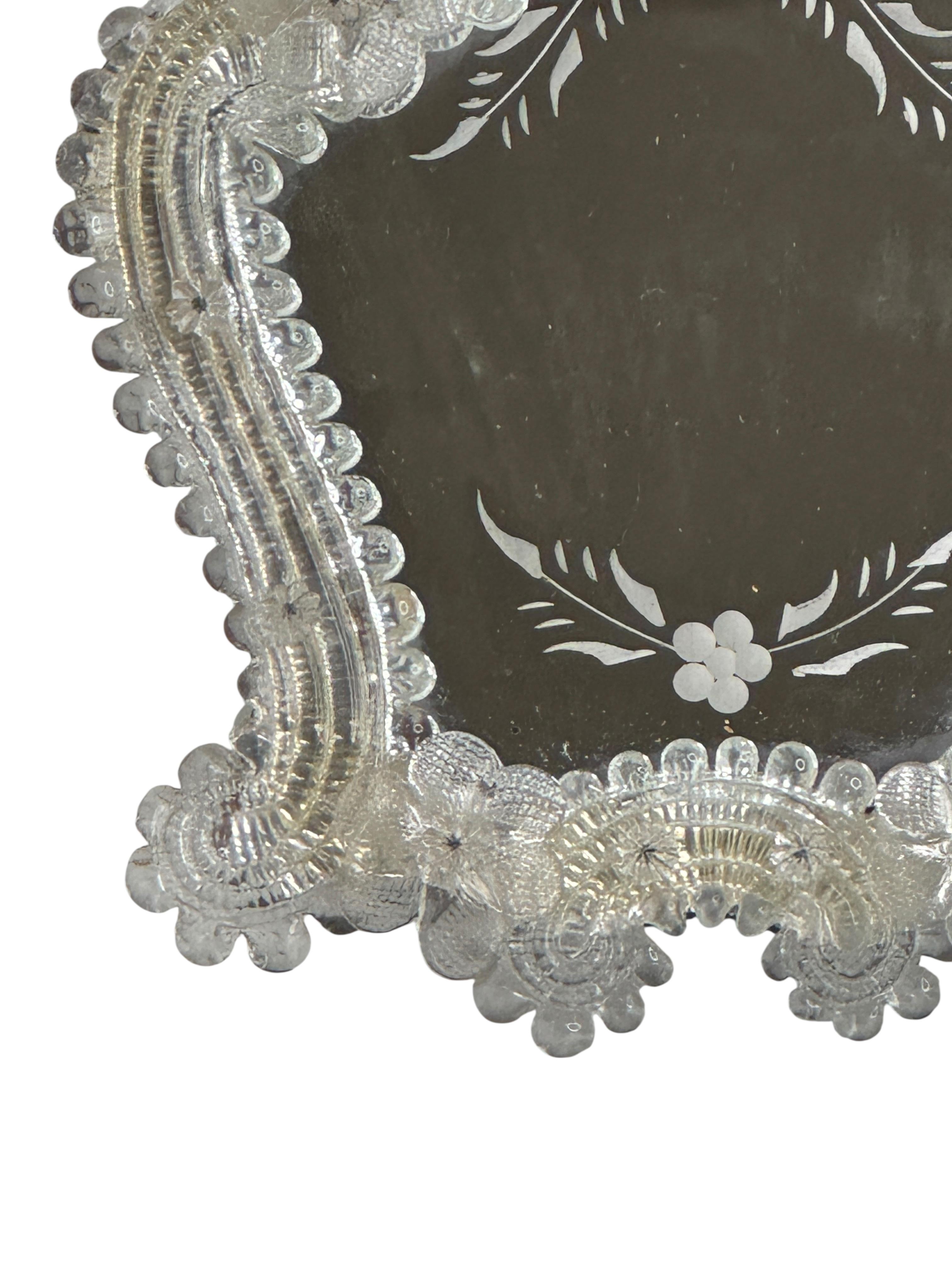 Un magnifique miroir de courtoisie en verre de Murano entouré de fleurs en verre faites à la main. Avec des signes mineurs d'usure comme prévu avec l'âge et l'utilisation. Une belle addition à n'importe quel dressing. Trouvé dans une vente