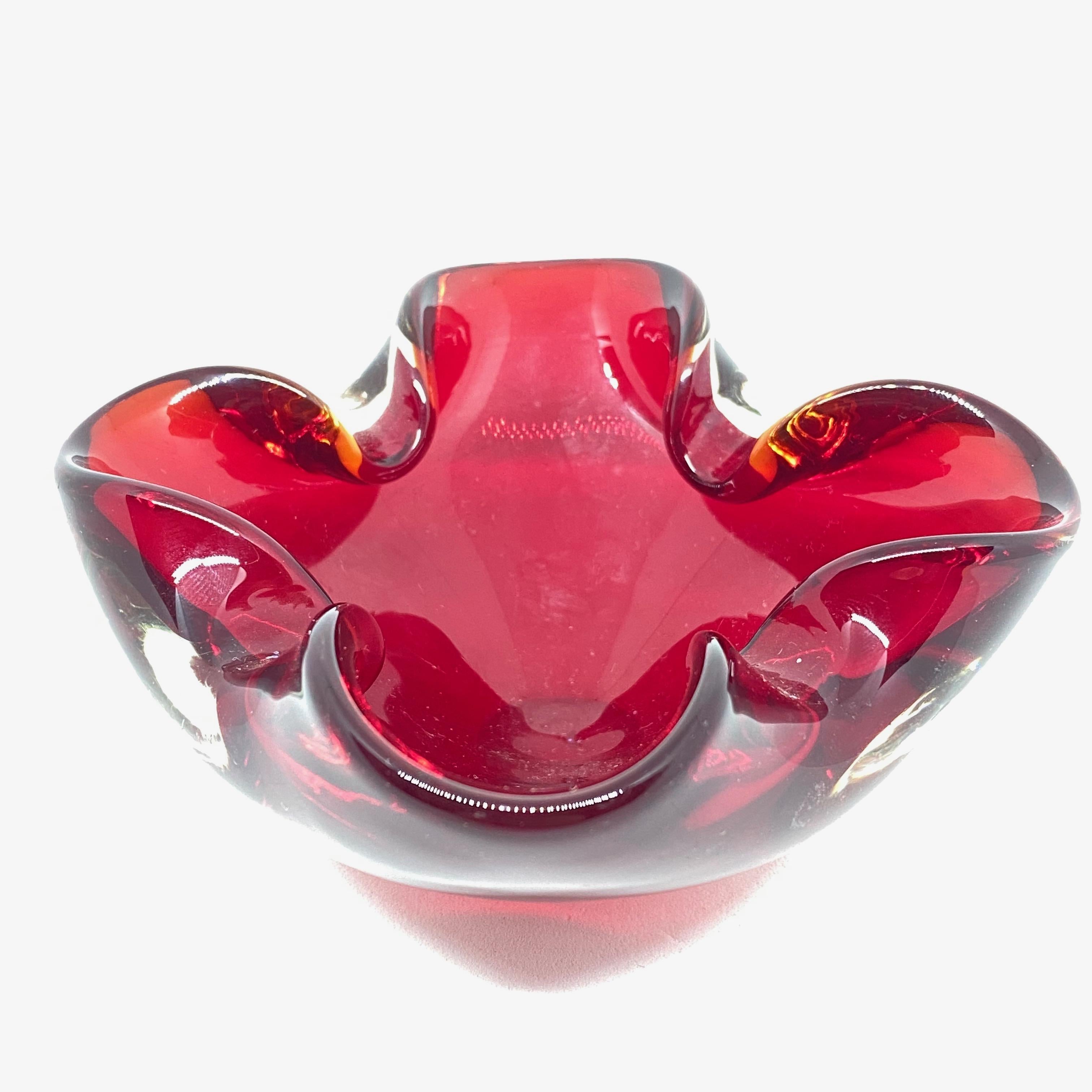 Gorgeous hand blown Murano art glass piece with Sommerso and bullicante techniques. A beautiful organic shaped bowl, catchall or ashtray in deep red, Italy, 1970s.