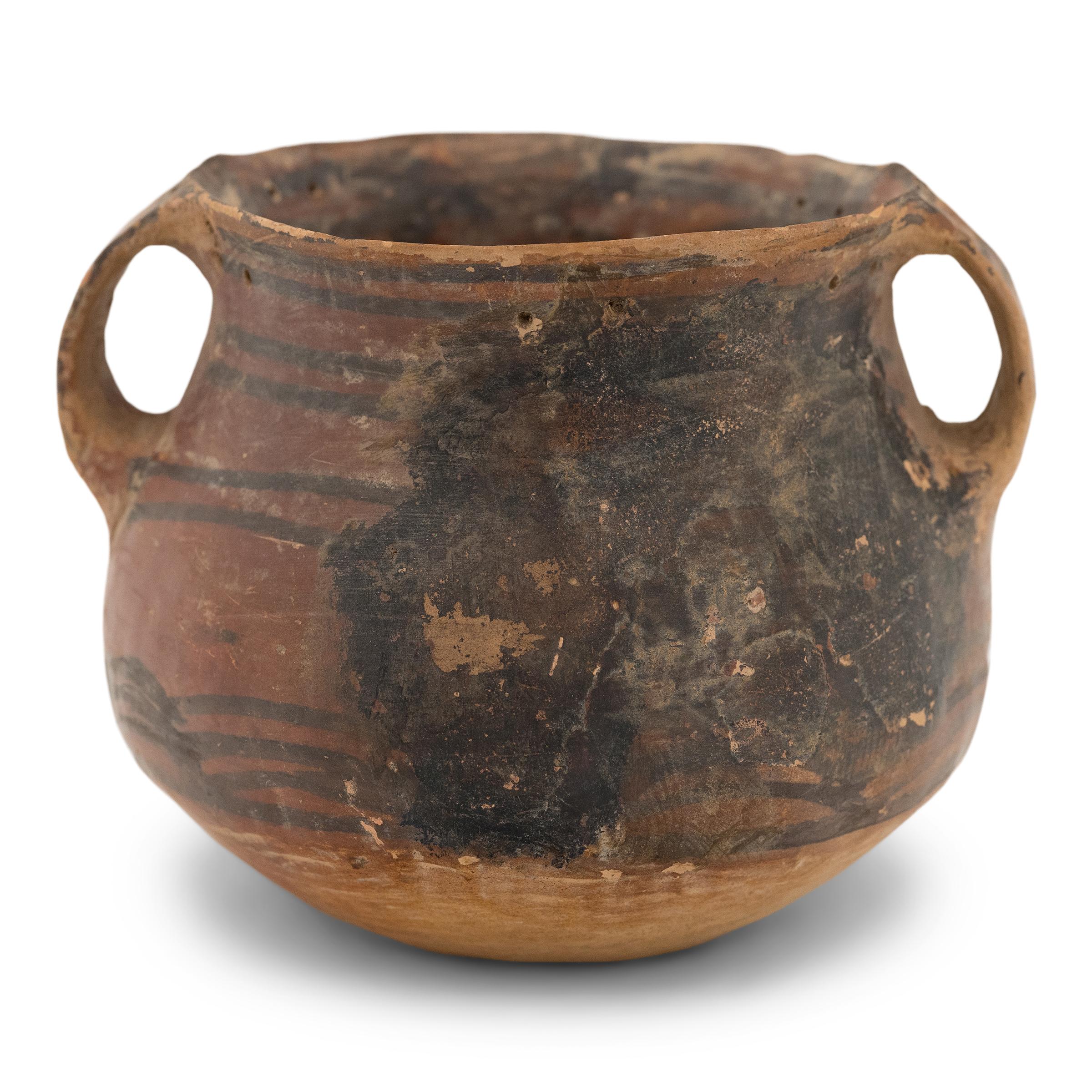 This petite ceramic jar is believed to be a later example of Neolithic Chinese redware pottery of the Yangshao culture. Although its exact age is unknown, the jar was likely created around 5000–3000 B.C.E.. Hand coiled and burnished on a