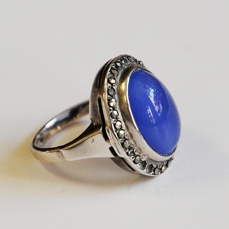 Decorative and medium blue stone vintage silvering on a decorated silver base. Perfect for your little finger. From the 1950s.

Silverstamped: 925. Measures: Inner diameter is 15.5 mm. Size of stone 15 mm x 11 mm. Height: 20 mm. Lovely design.