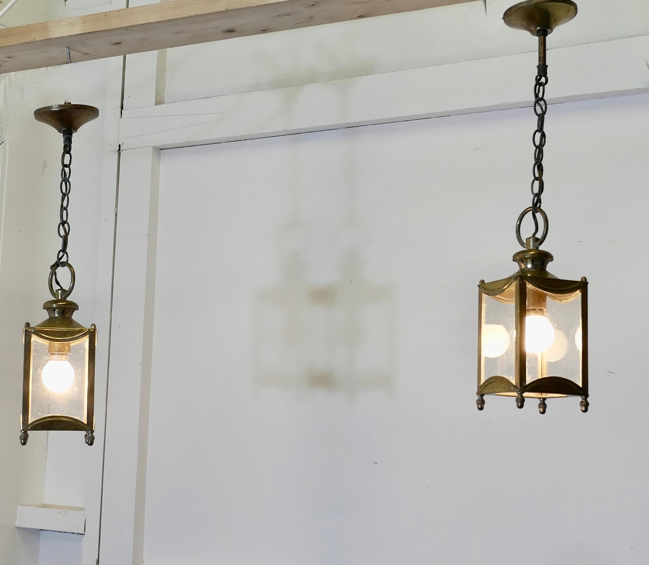 Petite Pair of French Brass and Glass Hall Lantern Lights

This is a lovely pair, each lamp has 4 sides and a rectangular shape, this very attractive pair give a bright light when lit, the lantern frames are brass and they each hang from a brass