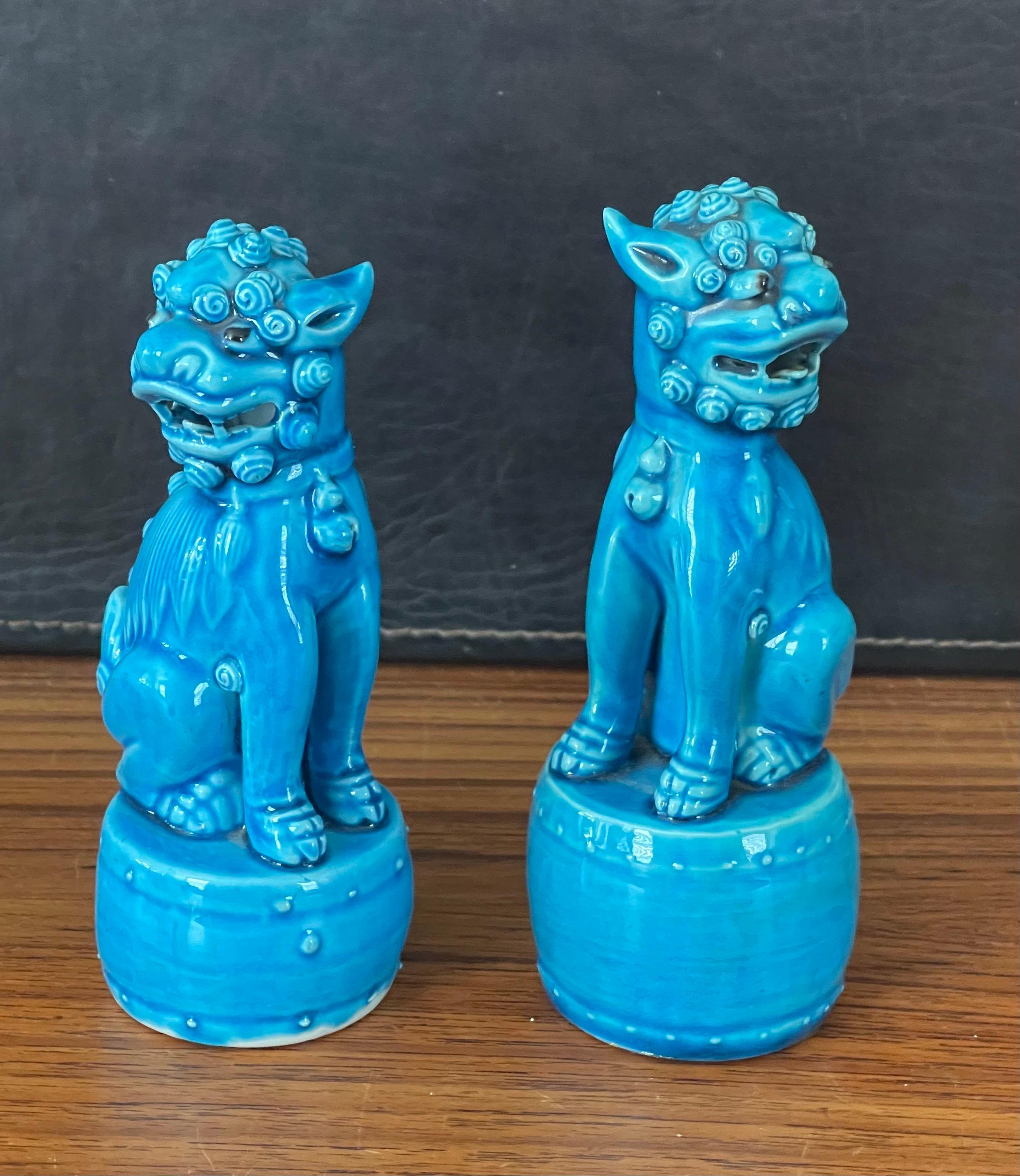 Coppia di piccole sculture vintage in ceramica blu turchese di foo dog, circa 1960. Questi guardiani simbolici presentano una bellissima tonalità turchese, oltre a grandi linee e volute nella ceramica. 
La coppia è in ottime condizioni, senza