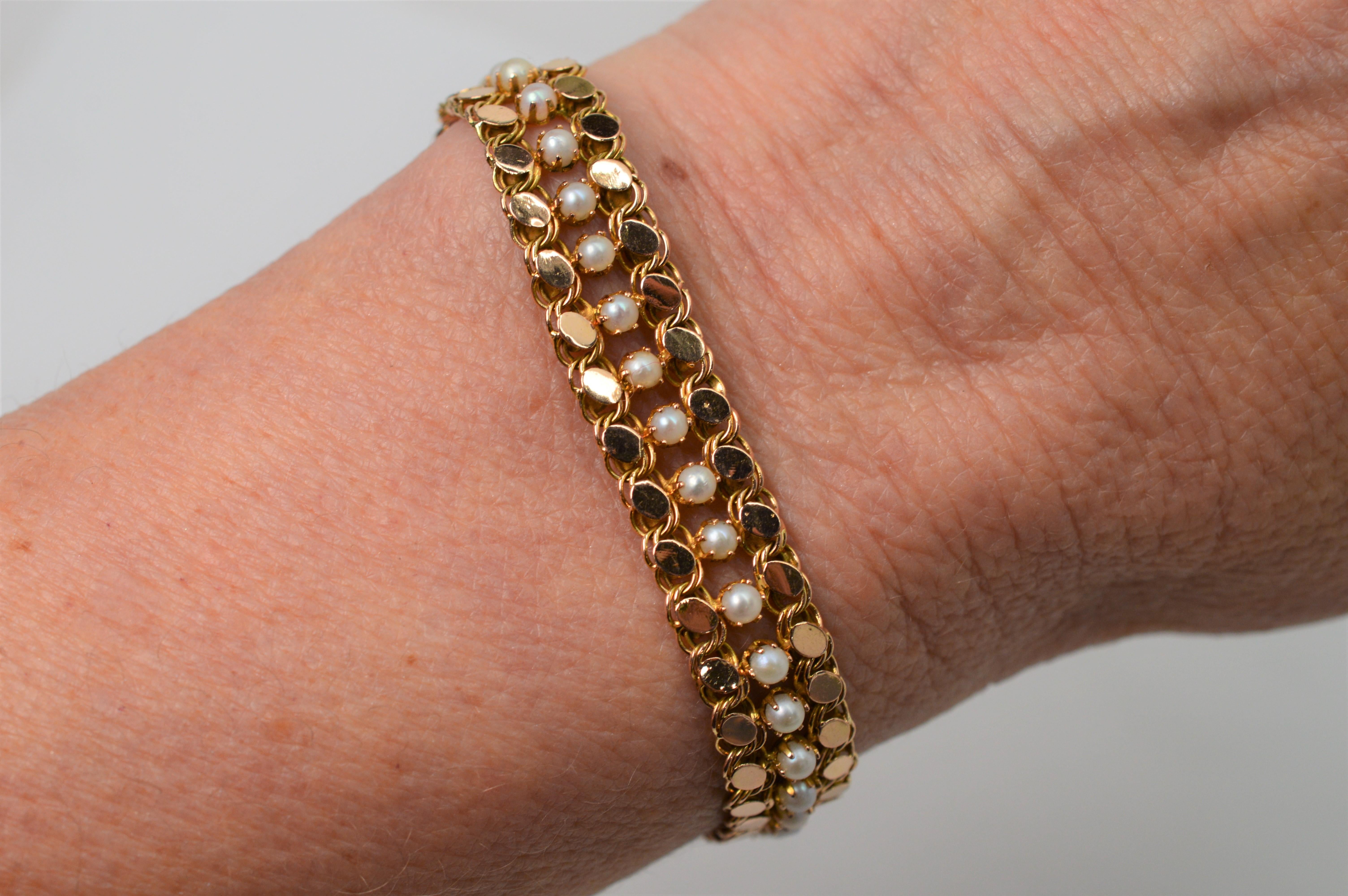 Fluid elegance with timeless style achieved through intricate links of bright 14k fourteen karat yellow gold each adorned with bezel set petite round white pearls placed within the center of each link.  Effortlessly draping the wrist, this bracelet