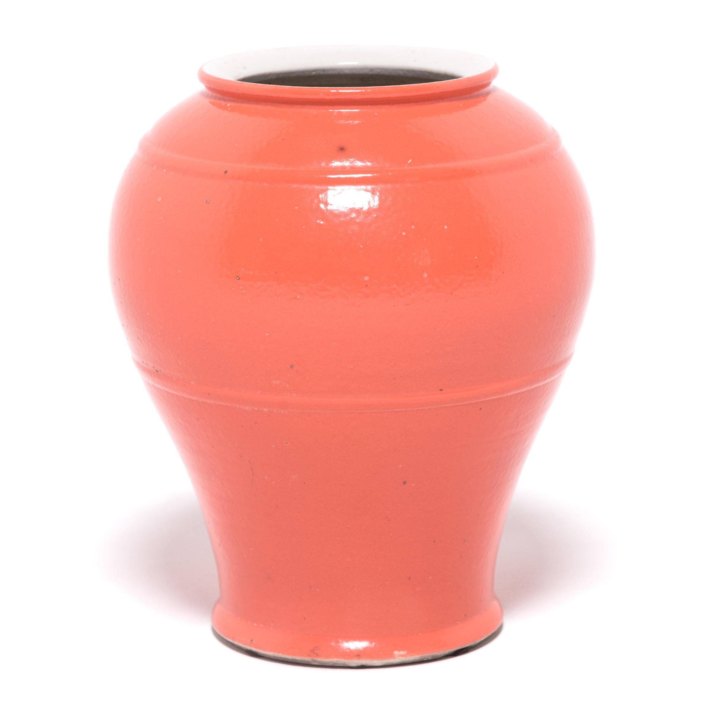 Ce grand vase conique réinterprète les courbes classiques des céramiques chinoises traditionnelles avec des lignes simplifiées et une glaçure orange kaki éclatante. Sculpté par des artisans de la province chinoise du Zhejiang, ce vase présente une
