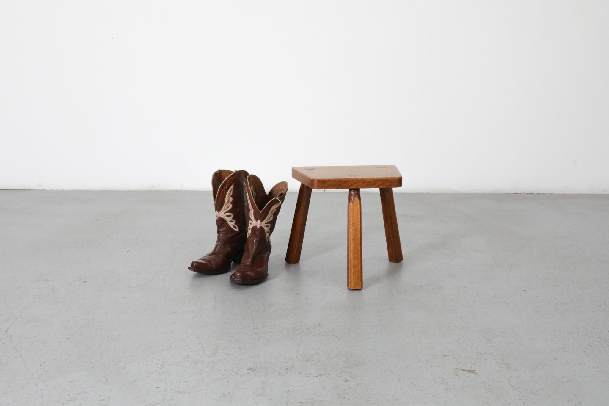 This little Brutalist solid oak fireside or milking stool with heavy patina. It can be used as a little seat or side table, and has a simple and crude construction with visible wear and patina consistent with it's age and use. 