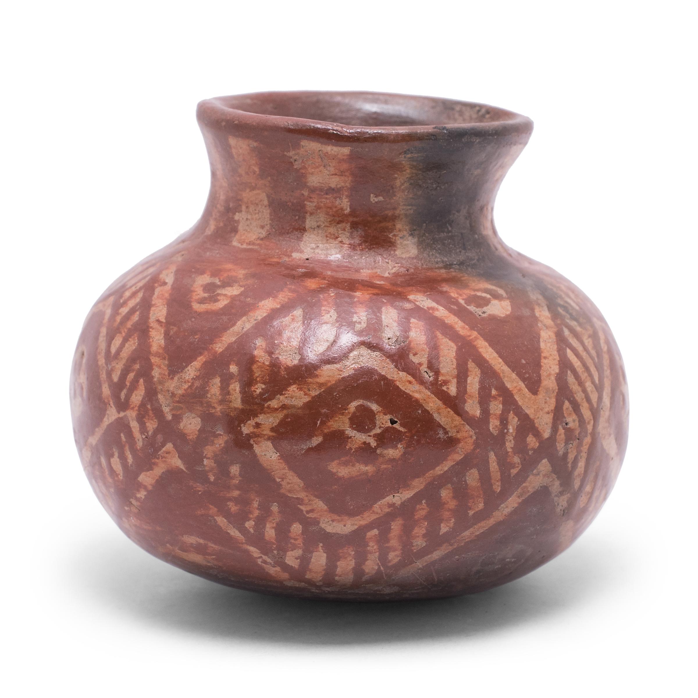 This little jar is a beautiful example of Mesoamerican pottery, decorated with red and white slip clay in the style of Chupícuaro ware. The olla vessel has a globular body with a rounded base, constricted neck, and slightly flared lip. The exterior