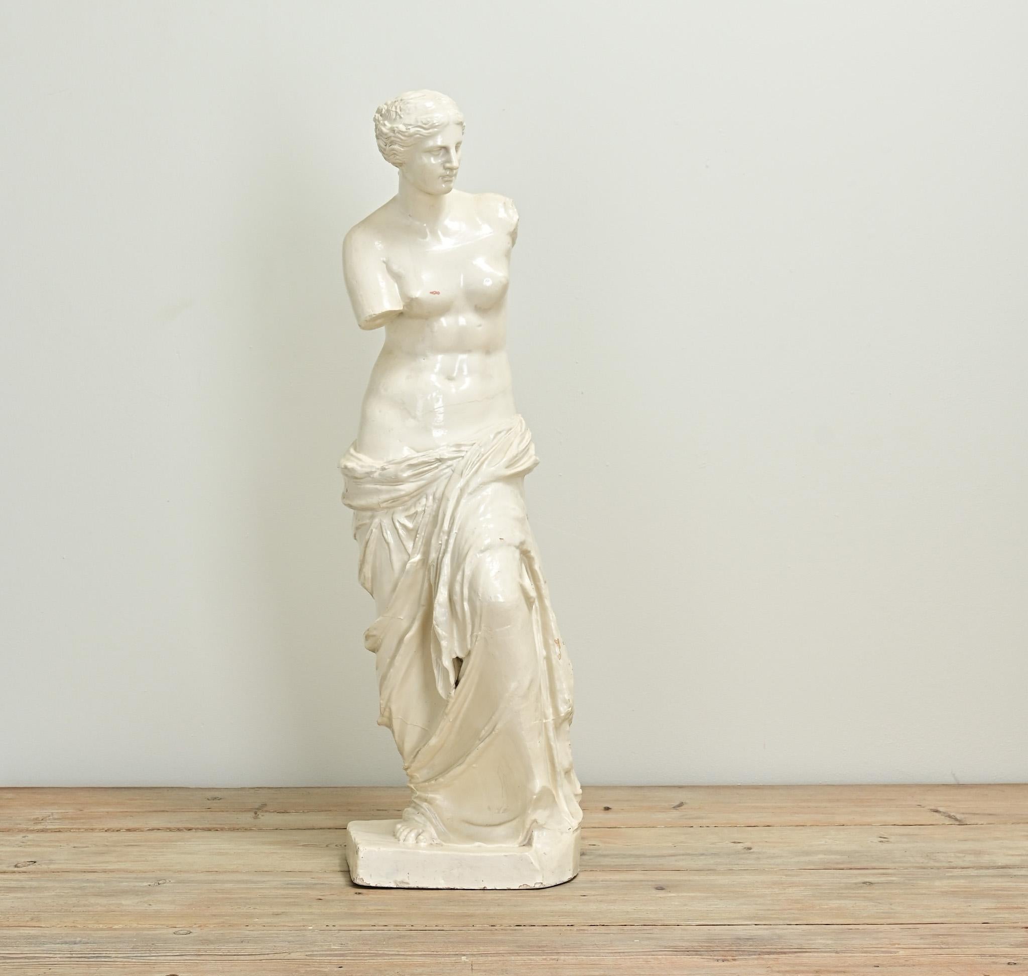 This petite replica of the iconic statue, Venus de Milo, is just under three feet tall. The original statue was found on the island of Milos, and is believed to be the Greek goddess, Aphrodite, referred to in Roman mythology as Venus. This