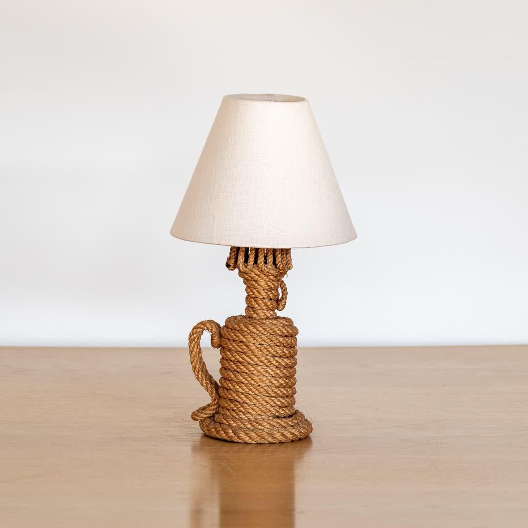 Petite rope table lamp by Adrien Audoux & Frida Minet, France, 1960s. Beautiful circular rope base with curvy rope handle and rope spiral detail on side. New tapered linen shade. Nice vintage condition showing some age and patina. Newly re-wired.