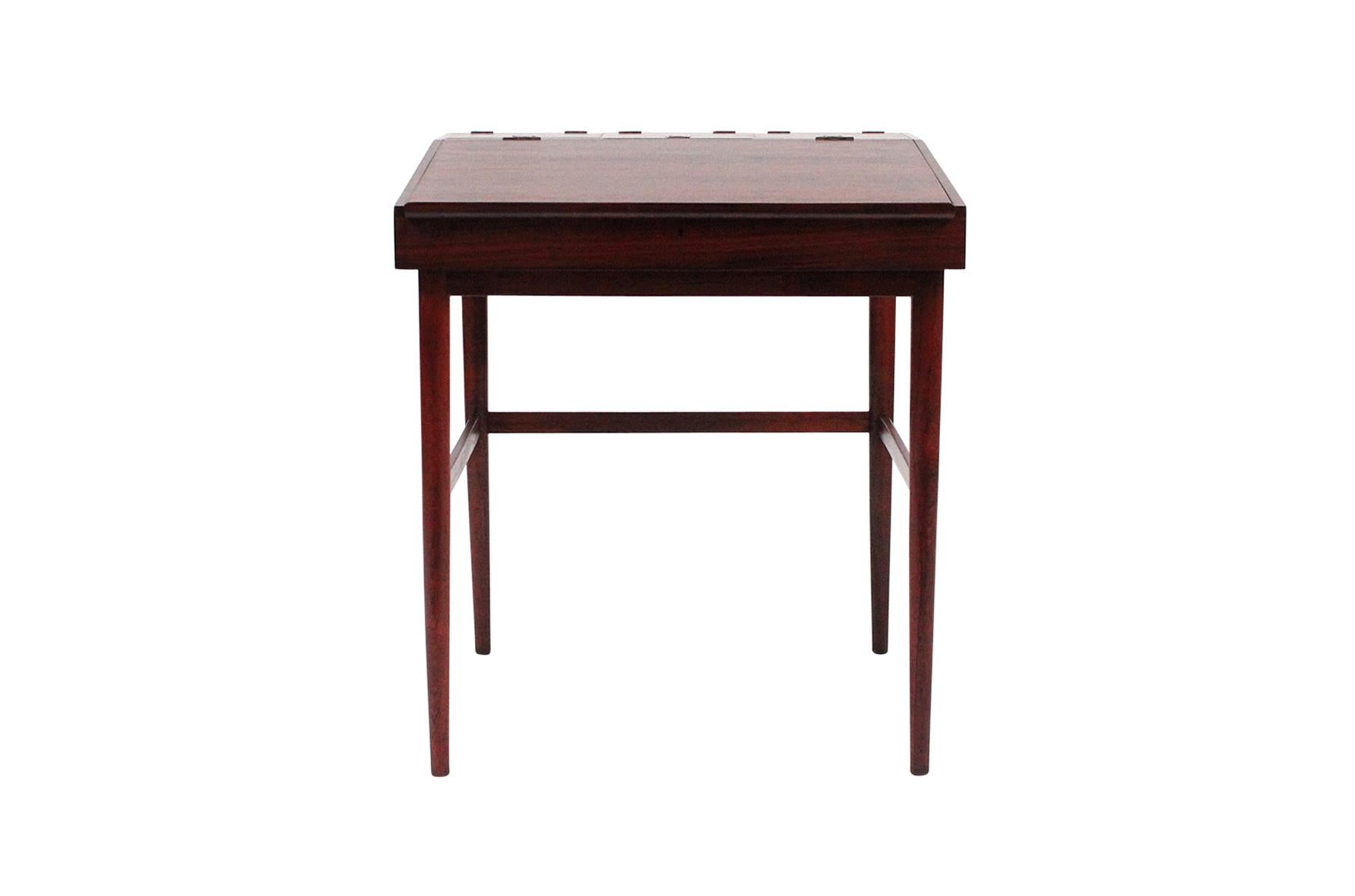 Rare rosewood writing desk by Finn Juhl for Niels Vodder, Denmark, 1942. This diminutive desk features a lift-top with open storage and three compartments with hinged tops. A rare and fine example in rosewood.