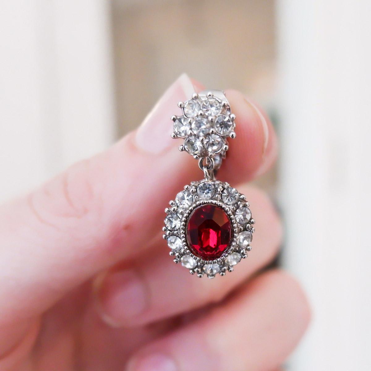 ALL CINER JEWELRY IS MADE TO ORDER. PLEASE ALLOW 10 BUSINESS DAYS FOR OUR ARTISANS TO MAKE YOUR JEWELRY FOR YOU! 
Charmingly sweet, these rhodium plated petite drop earrings have crystal rhinestones that illuminate the ruby drop. 
Materials:
Genuine