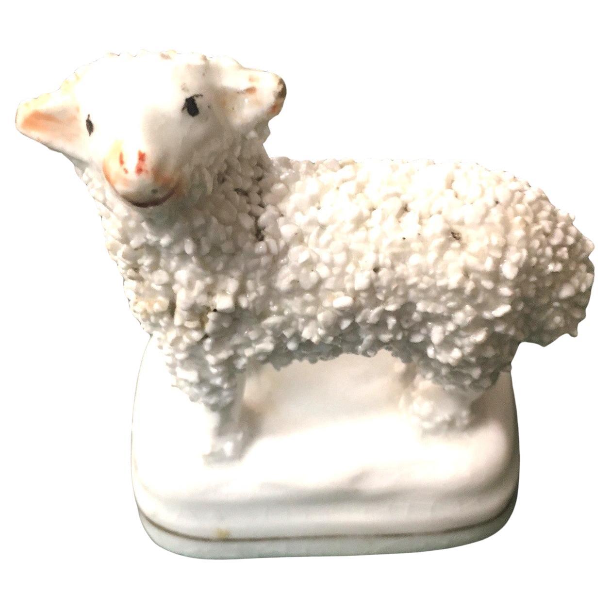 Questo affascinante esemplare d'epoca vittoriana è realizzato in porcellana Staffordshire di qualità e presenta un'adorabile lana d'agnello arricciata, occhi rossi dipinti a mano, naso nero con sfumature marrone e sfumature intorno alle orecchie. An