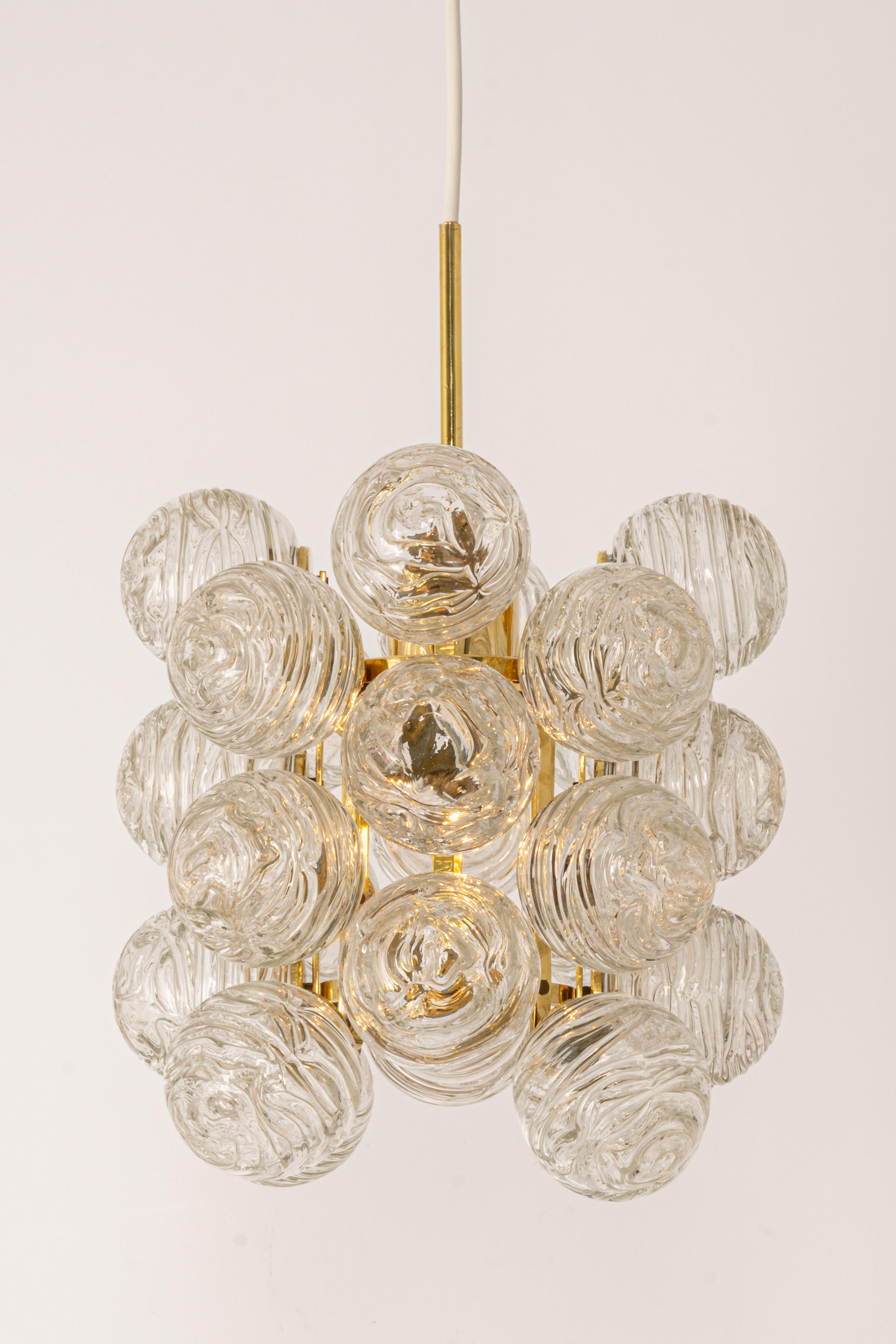 A petite midcentury pendant made by Doria Leuchtern, manufactured in Germany, circa 1970-1979.
The pendant is composed of many Murano glass swirl textured glass elements (snowballs) attached to a brass frame.

Sockets: 1 x E27 standard bulb. (Up