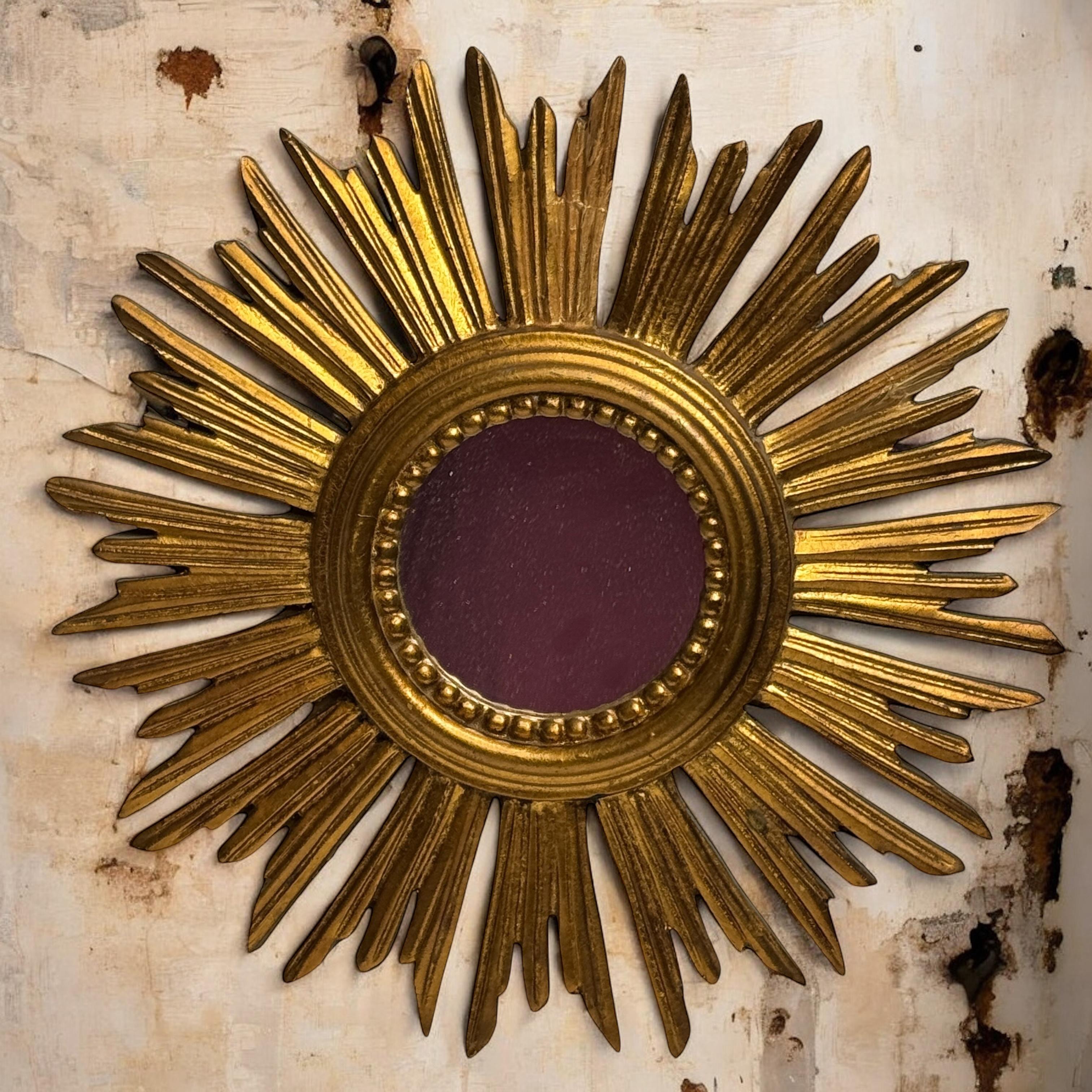 A gorgeous starburst sunburst flat mirror. Made of gilded wood. No chips, no cracks, no repairs. It measures approximate: 12 3/4