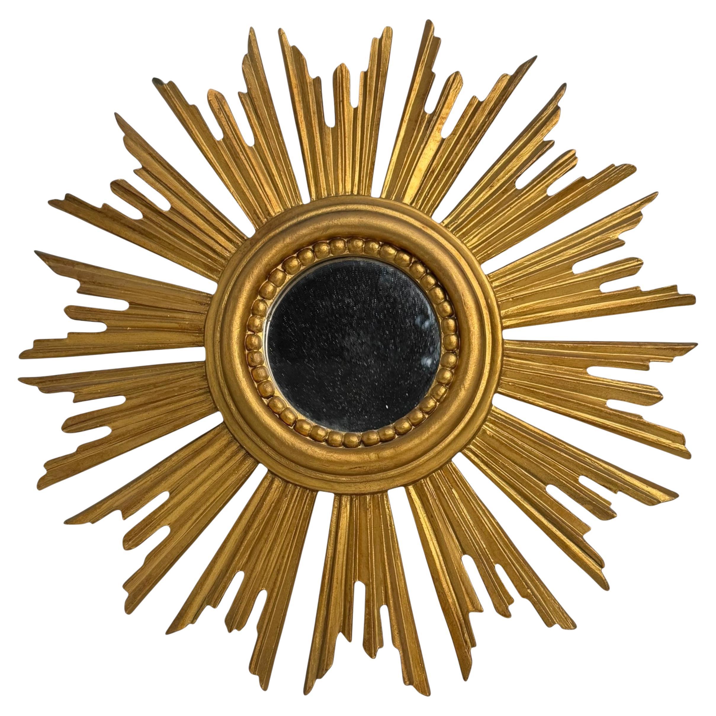 A beautiful starburst sunburst flat mirror. Made of gilded plastic. It measures approximate 12 1/4