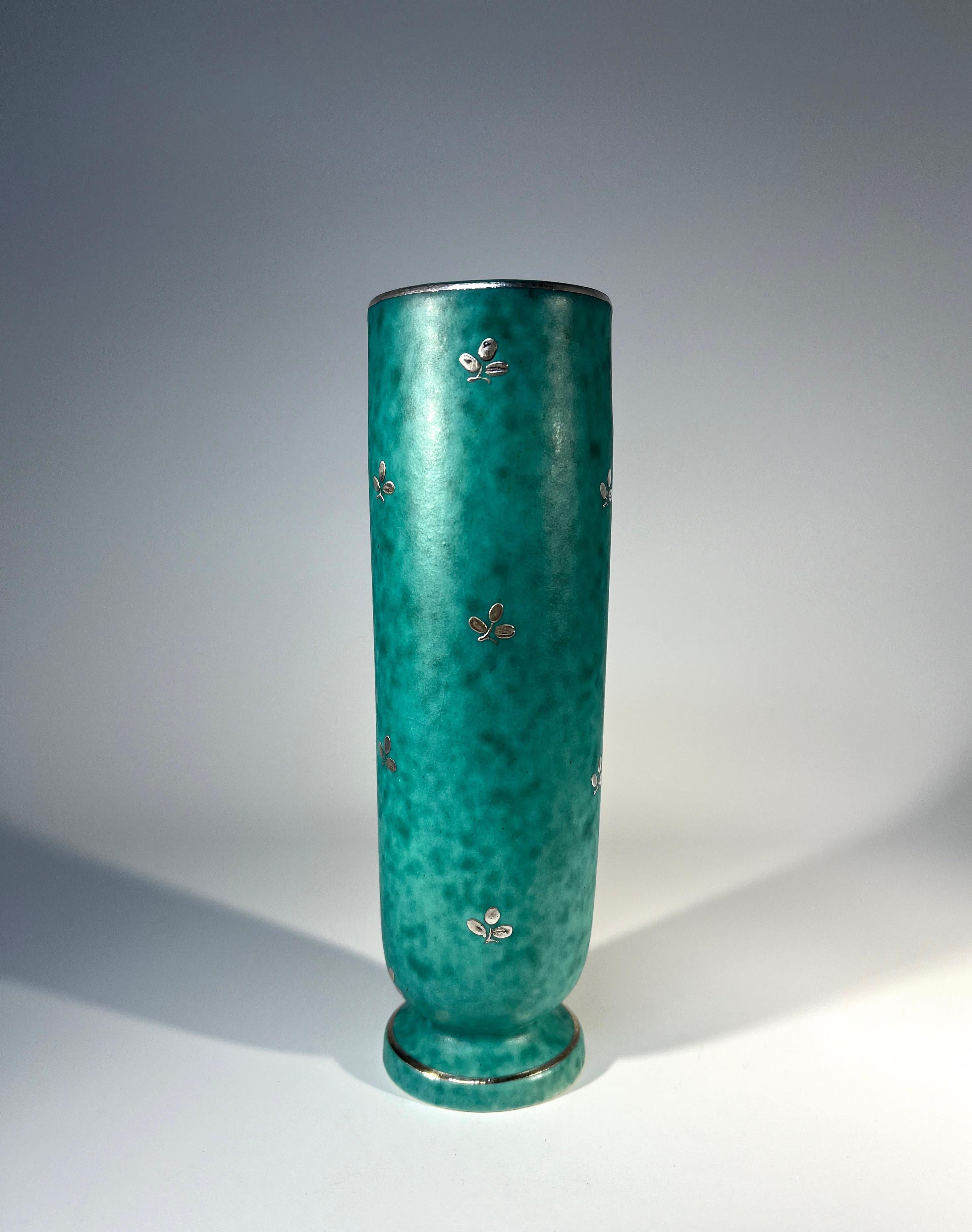 Petite vase by Wilhelm Kage for Gustavsberg, Sweden from the Argenta collection.
Decorated with trefoil flower sprigs of applied silver on mottled green stoneware.
Silver bands to rim and foot
Circa 1960's
Base marked Gustavsberg Argenta 1029 B, A V