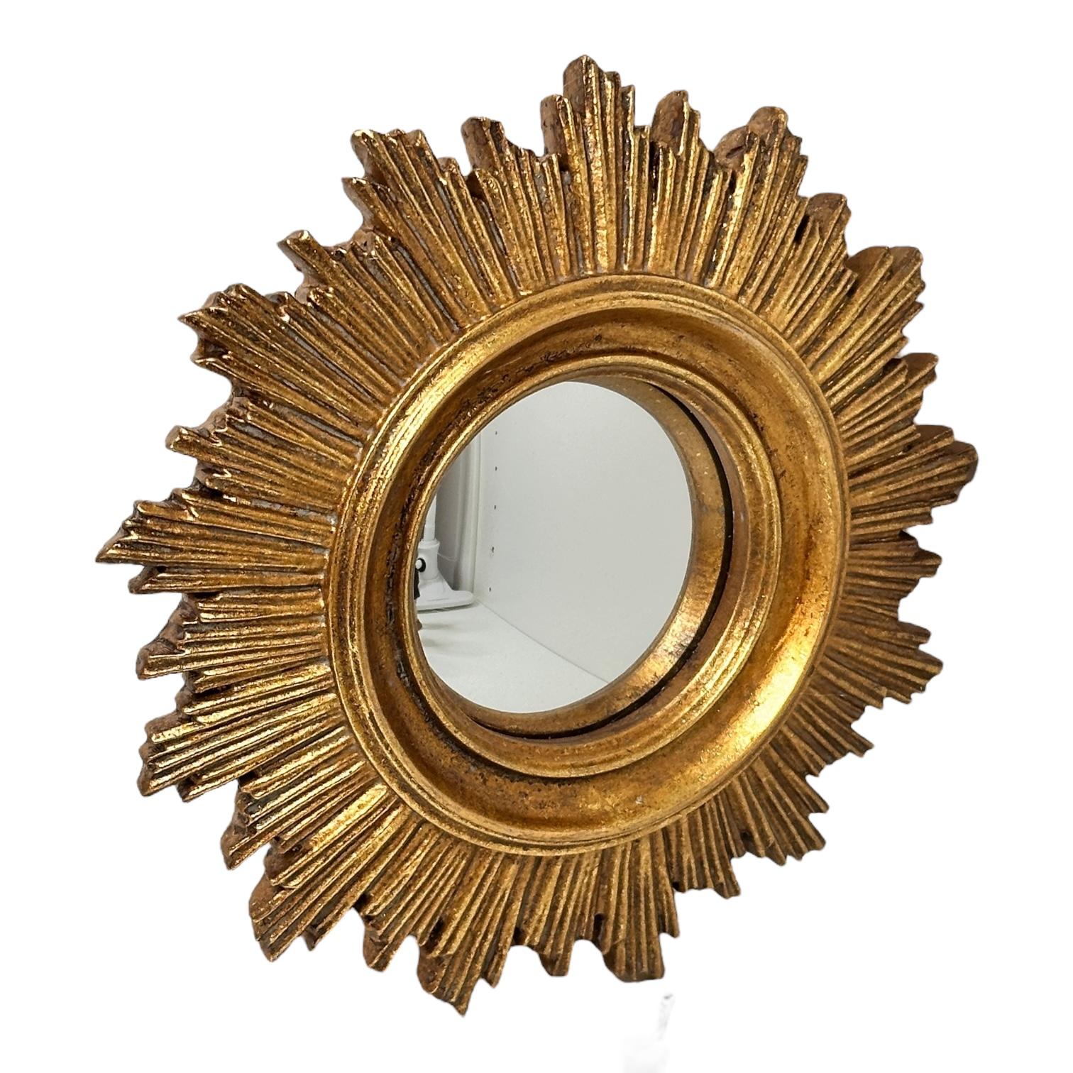 Un joli miroir en forme de soleil ou d'étoile. En composition dorée. Il mesure environ 7