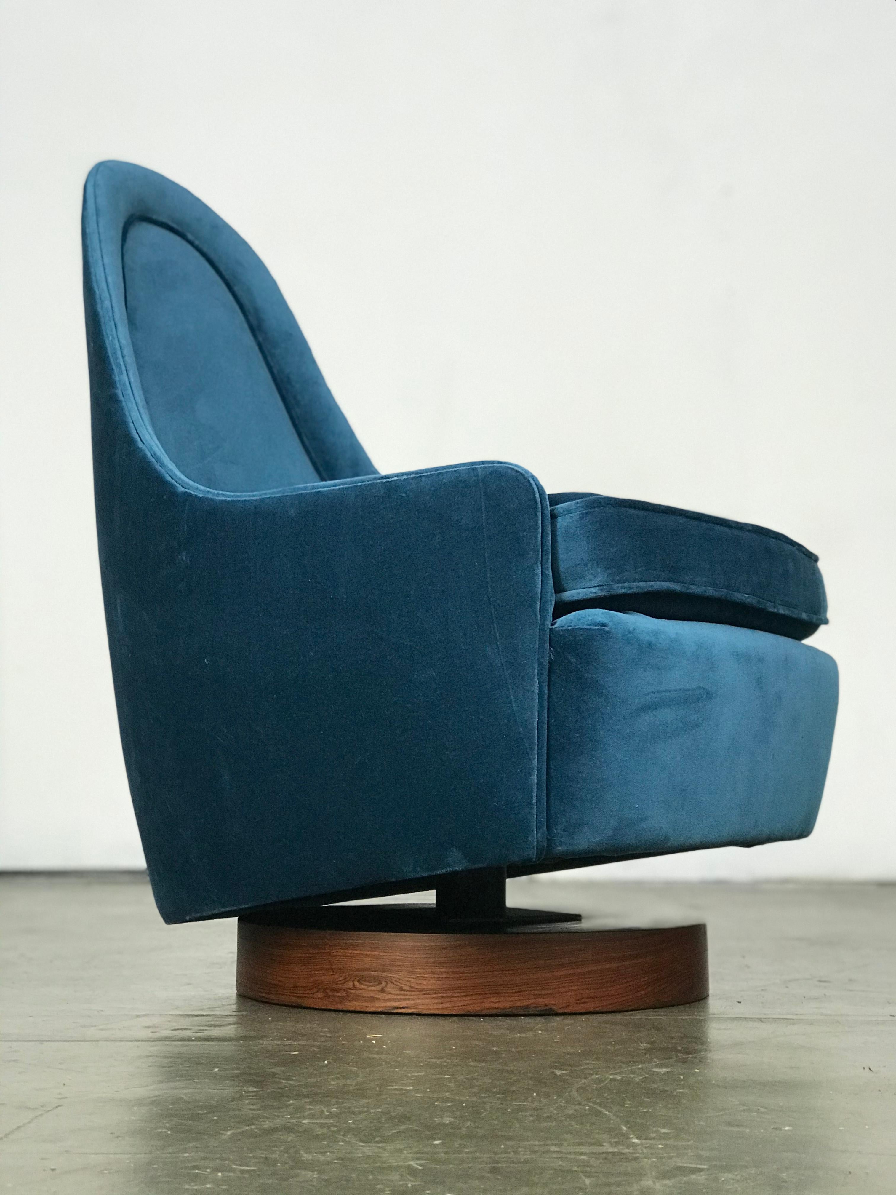 A small-scale rocking swivel chair on a rosewood base, designed by Milo Baughman for Thayer Coggin. When I spoke to the daughter of Thayer-Coggin, she said Milo Baughman designed these because he loved playing board games with his family and wanted