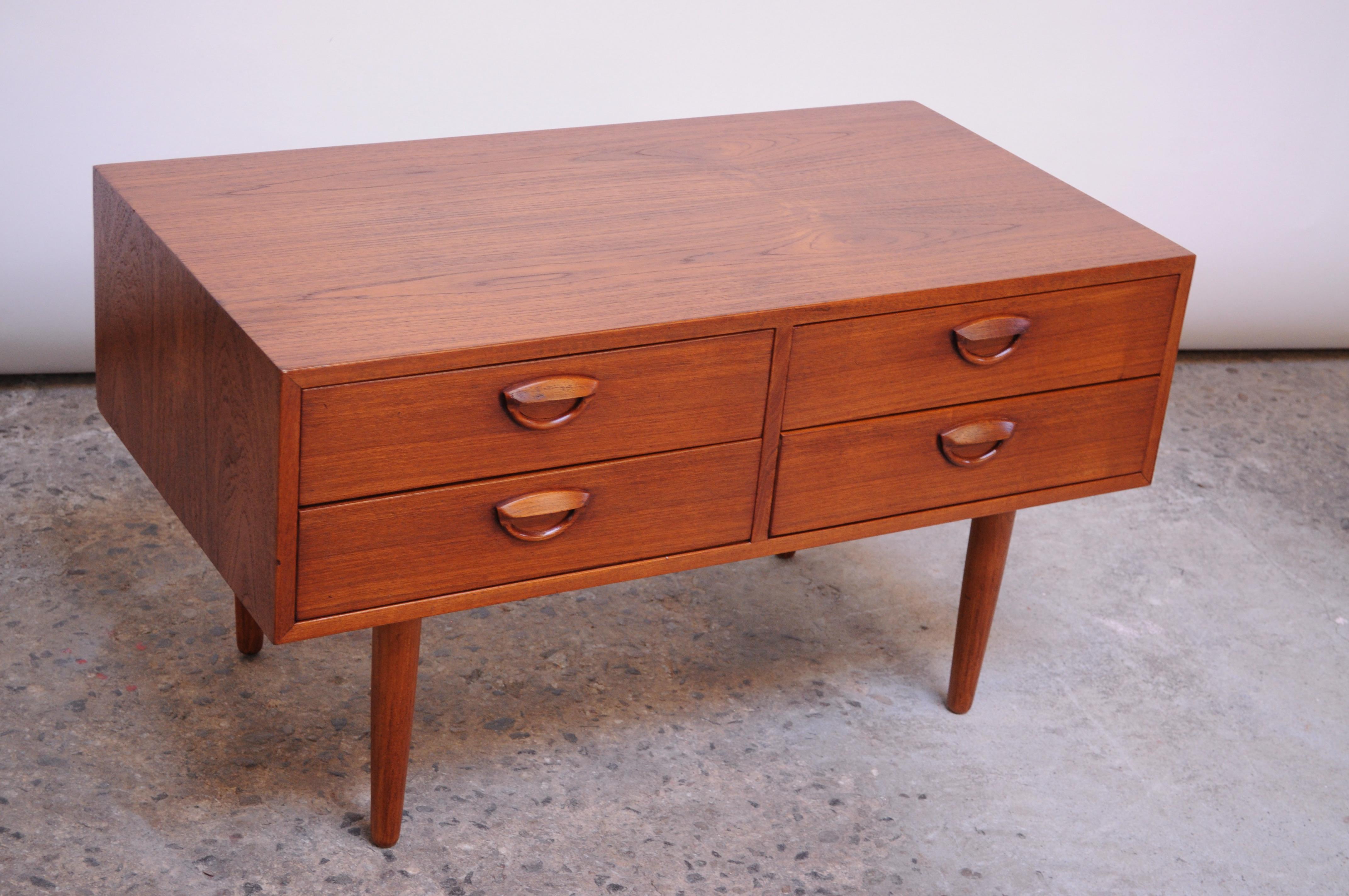 Kai Kristiansen for Feldballes Møbelfabrik small, low chest in teak. 
Handsome and compact piece, featuring four dove-tailed drawers with Kristiansen's signature eyelet drawer pulls.
Very fine, refinished condition; light wear remains (namely