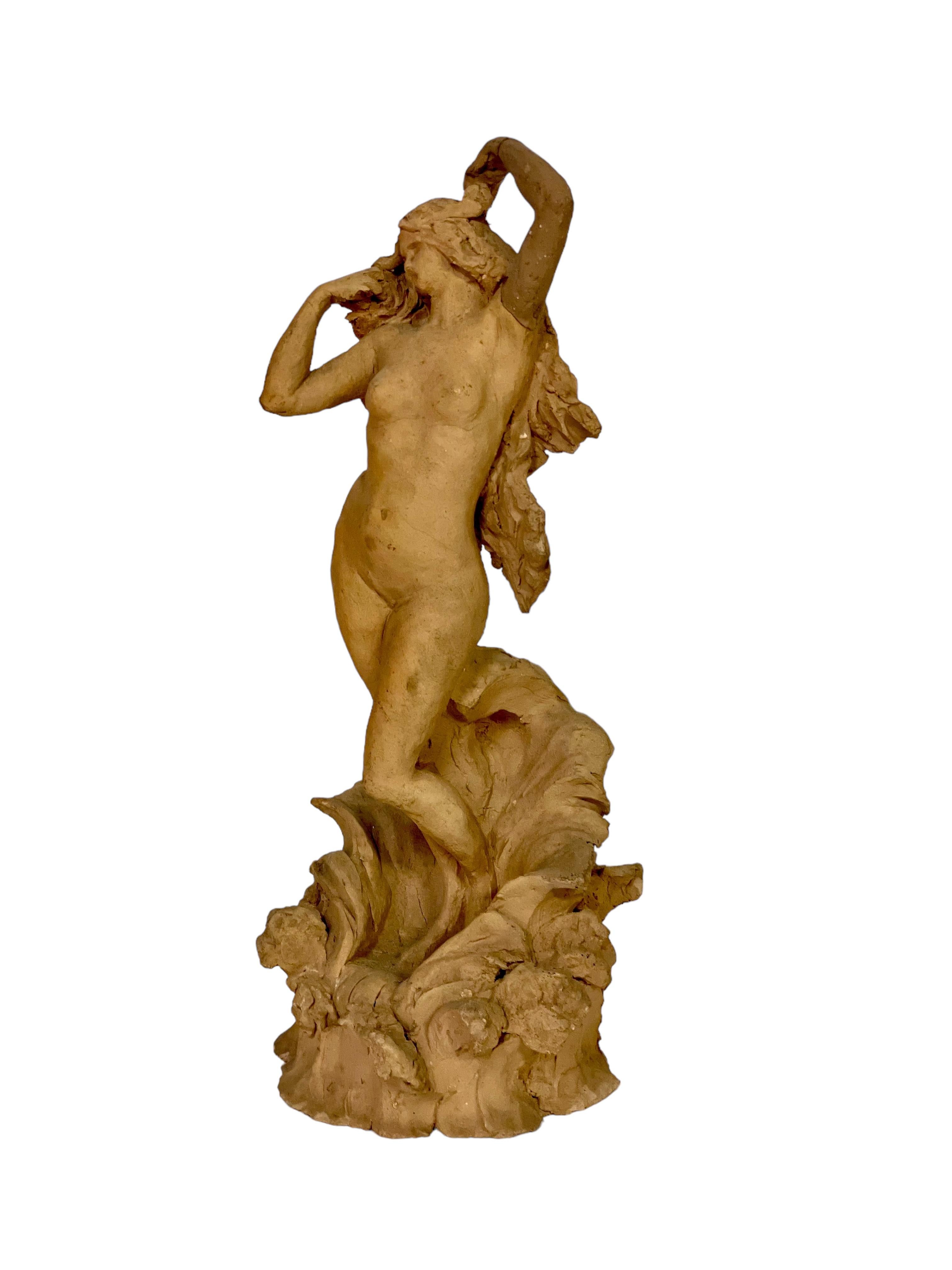 An exquisite terracotta statuette of a beautiful nude young woman with a serene countenance, her arms stretched up to fan her cascading hair. The setting in which she stands is embellished with low swirling waves or perhaps a seashell, reminiscent