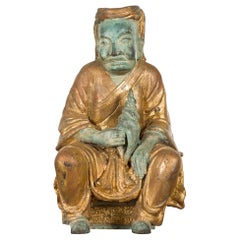 Petite Thai Verde and Gilded Statuette of a Seated Monk Holding a Conch Shell