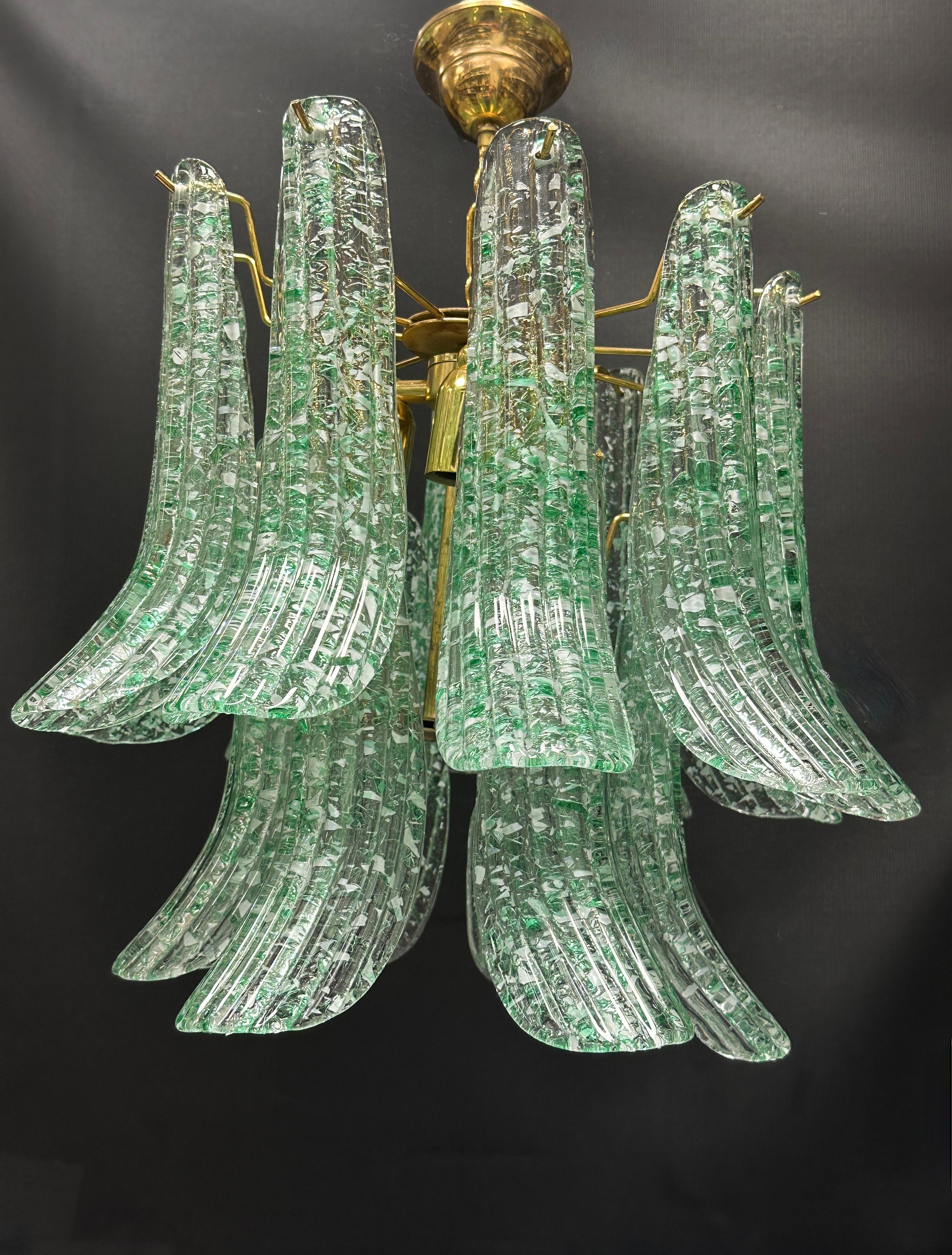 A stunning hand blown Italian three light Murano glass chandelier with brass frame. Clear and green flake ribbed glass elements. Hand blown at the Murano island in Italy. The Chain with canopy is approx. 10