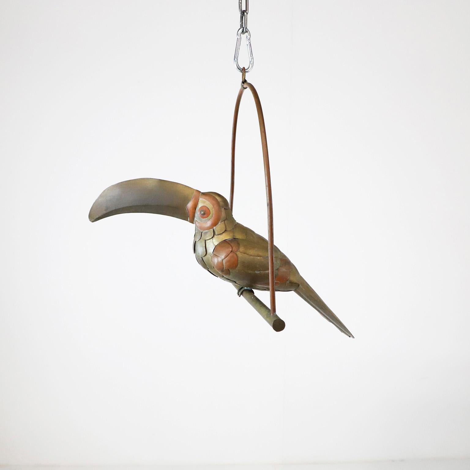 We offer this petite Toucan on hanging perch figure in the style of Sergio Bustamante, circa 1960 made in brass and copper with fantastic patina. Present some details.