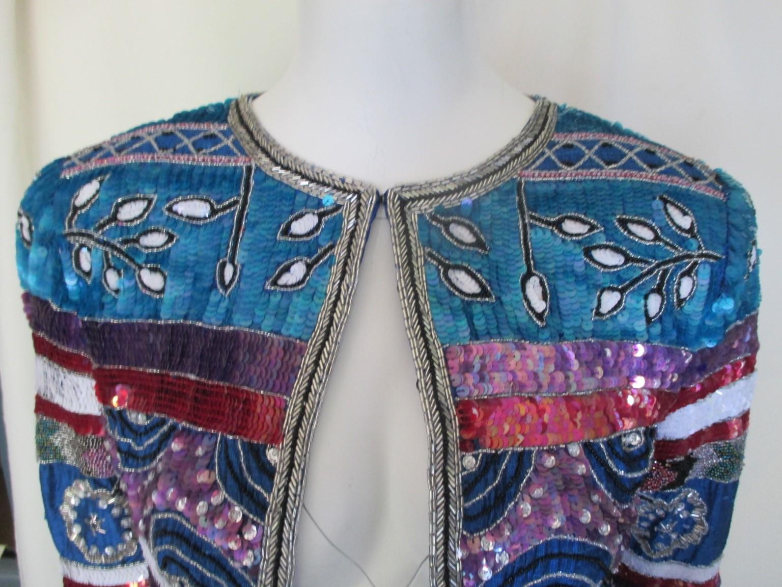 This vintage short jacket/bolero is embroided with colorful sequins, silk and has shoulder pads. 
We offer more exclusive vintage items , view our frontstore

Can be worn on jeans or evening dress.
Appears to be small, please refer to the