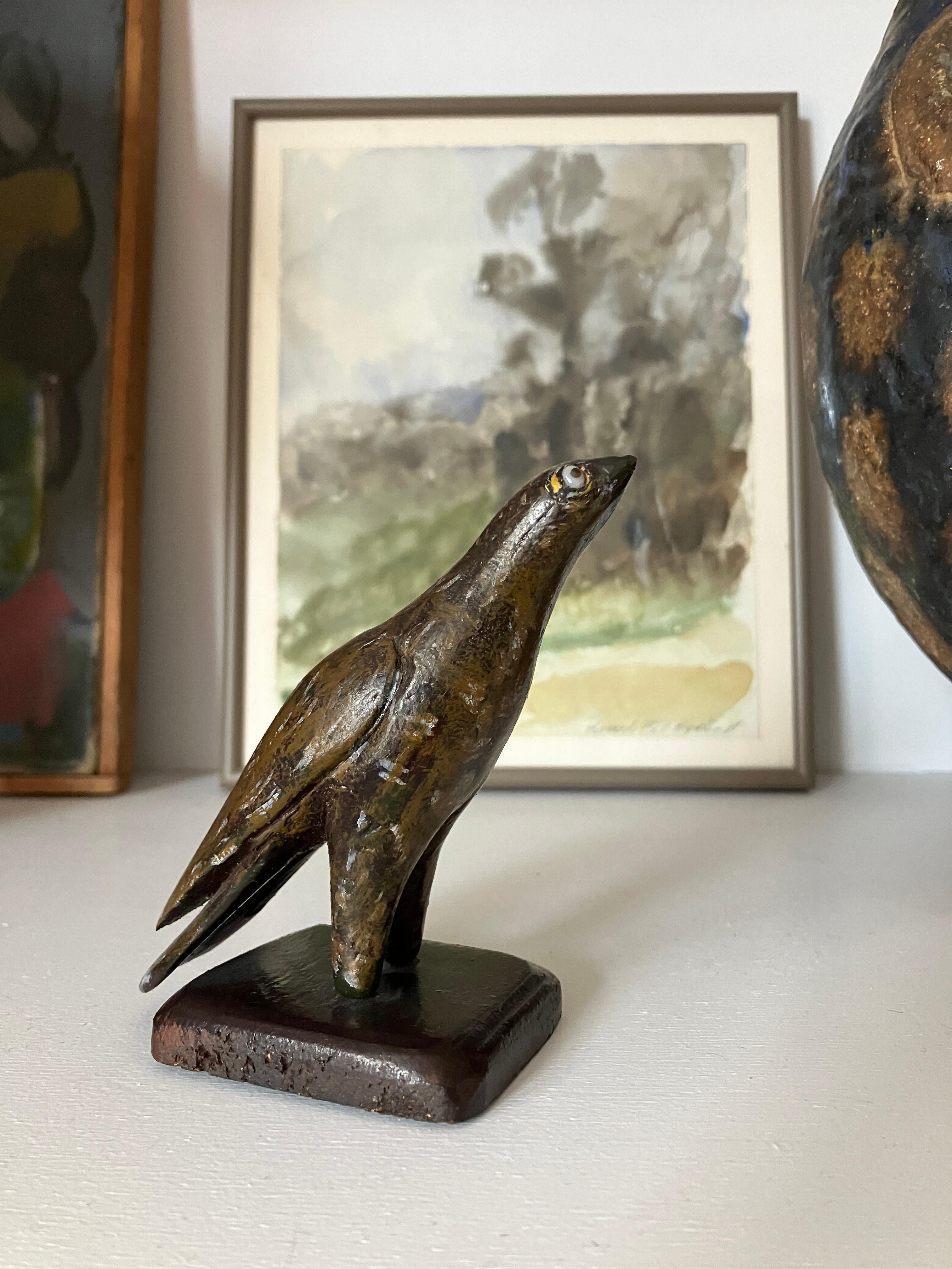 Gorgeous small bird standing on a wooden base. This is a bird of prey - a baby eagle perhaps. The Eagle has glass eyes. Beautifully hand-carved and painted. A lovely vintage item. This would make a great present. 