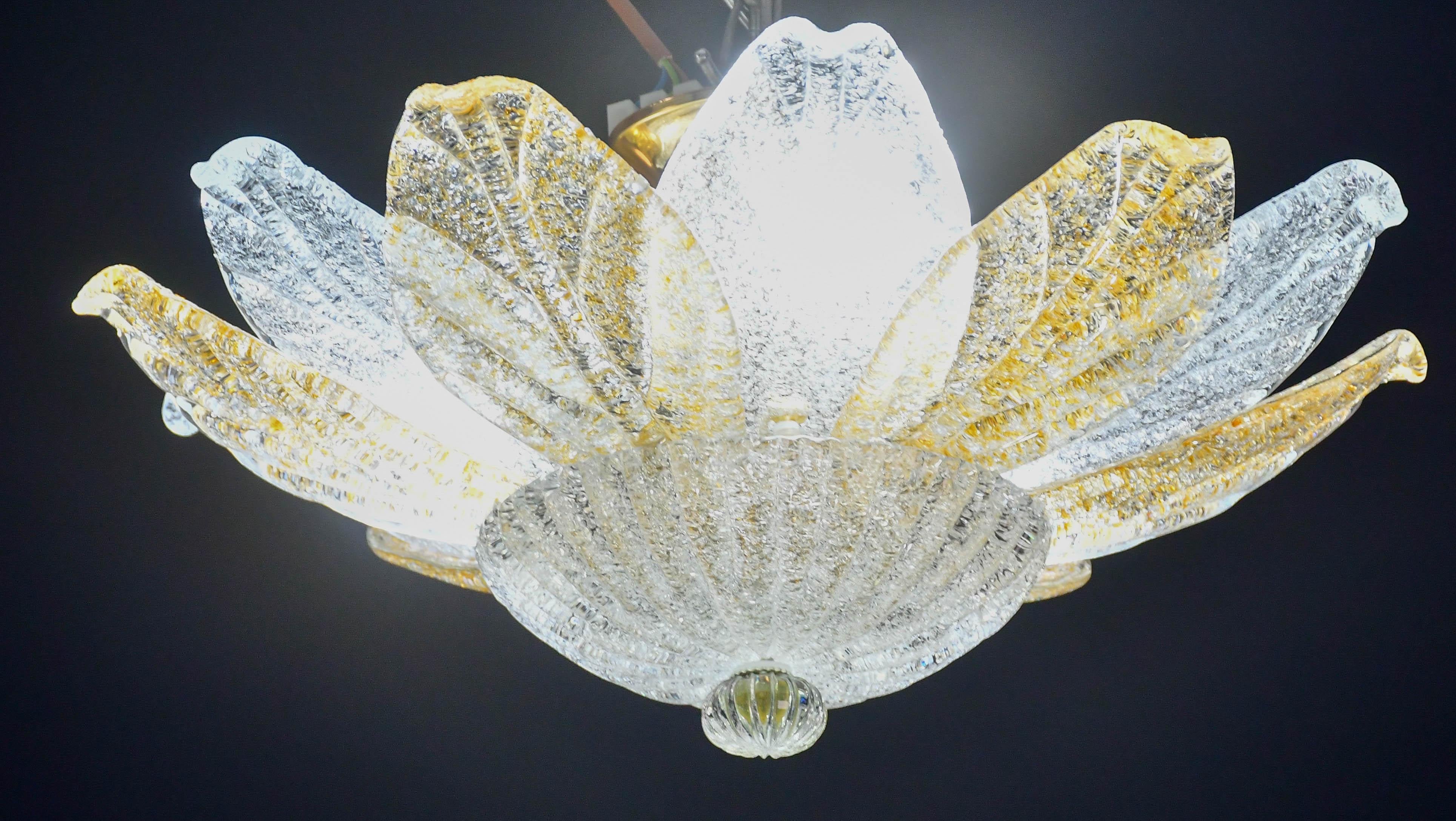Splendide plafonnier en verre de Murano avec des feuilles de verre de Murano alternées, ambrées et transparentes.

Période : vers 1970.

La lampe se monte sur 3 douilles européennes standard e14, avec possibilité de commutation pour les