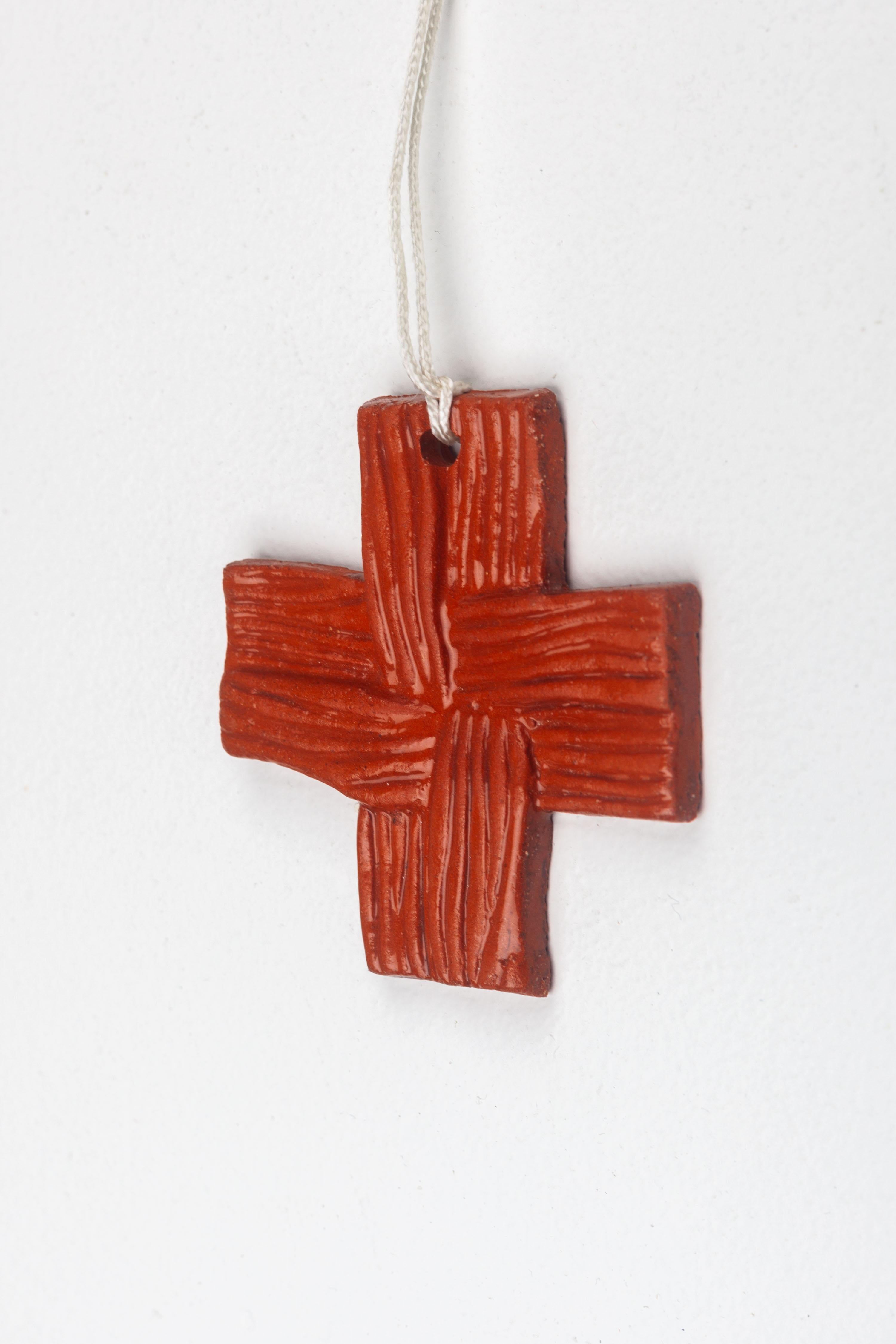 Kleines Wandkreuz aus Keramik, handgefertigt in Europa. Gewebtes Relief in glänzender, glasierter Terrakotta-Farbe. Unaufdringlich, zart und erdig.

Bei der Erkundung unserer Cross Collection werden Sie auf verschiedene Stile stoßen, die vom