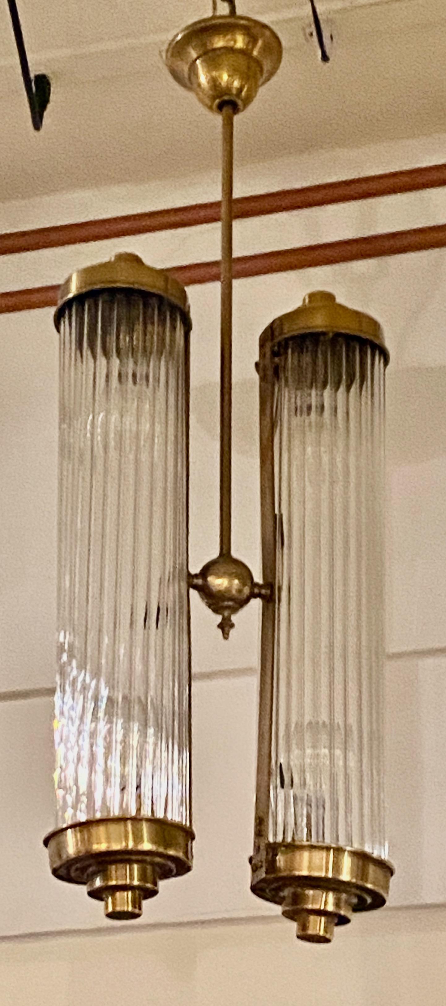 Lampadario Art Déco nello stile di Petito. I tubi multipli in vetro originali dell'epoca offrono un effetto molto insolito quando le luci sono accese. La lavorazione del metallo è precisa, con una tonalità rame/ottone che tiene in posizione tutti i