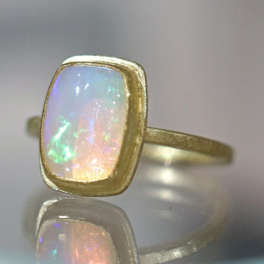 Fiery Ring handcrafted by acclaimed jewelry maker Petra Class featuring a stunning, vibrant 2.25 carat Ethiopian opal cabochon bezel-set in the designer's signature finely-textured 22k yellow gold frame atop an 18k yellow gold squared band. Opal has
