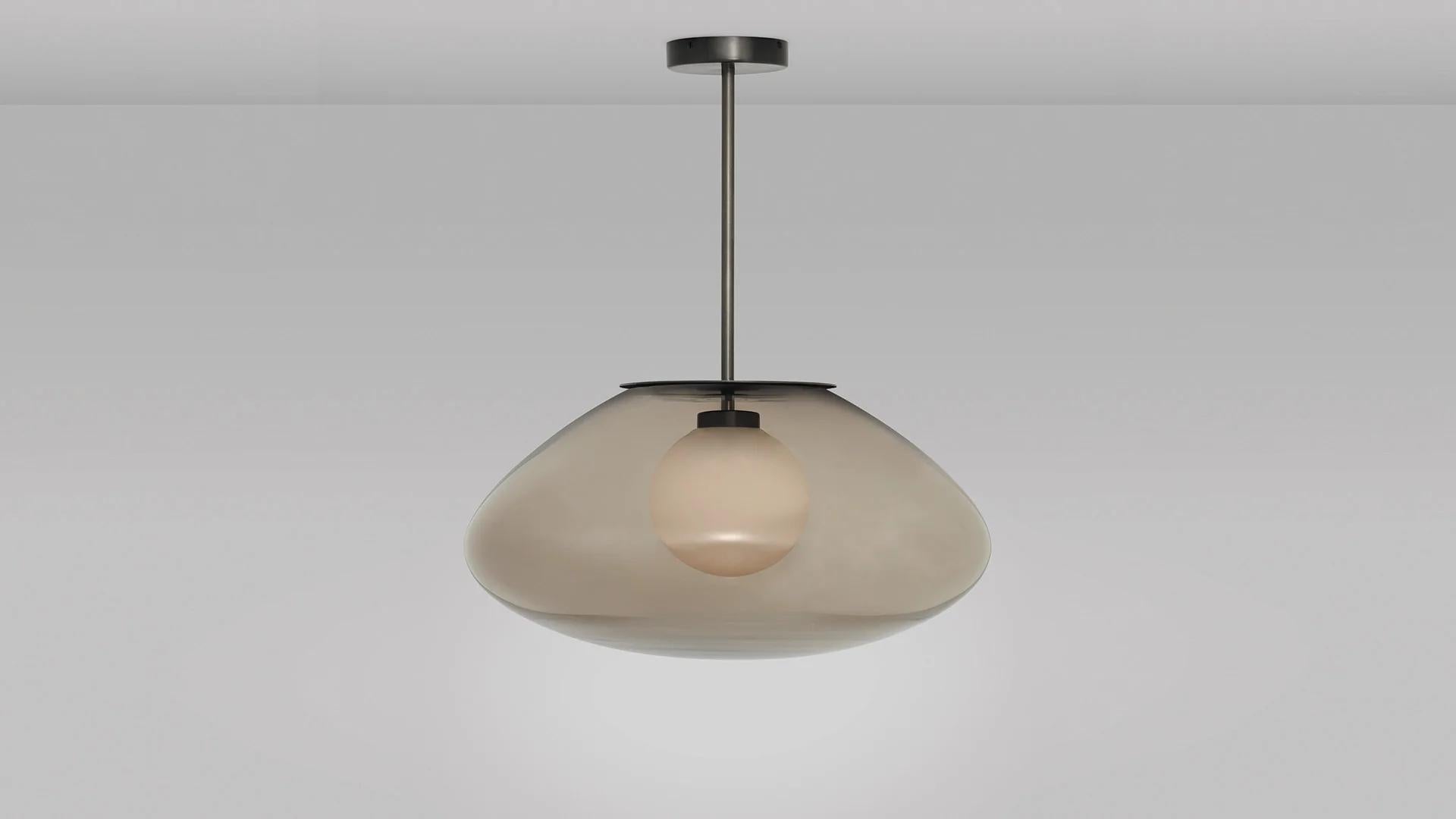 Petra large pendant by CTO Lighting.
Materials: dark bronze brass with smoked glass shade and white opal glass inner shade.
Also available in satin with smoked glass shade and hand shaped smoked glass inner shade,
satin brass with smoked glass
