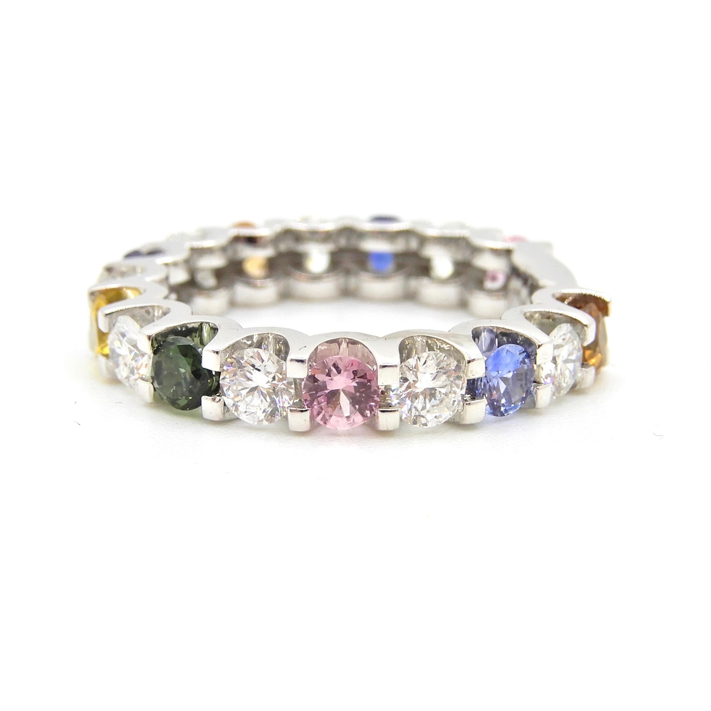 The Petra Rainbow Sapphire and Diamond Eternity Band Ring is a striking piece measuring approximately 3.39mm in width. The ring features one row of 17 x scalloped claw settings alternating 8 x 3.02-3.09mm round brilliant cut Diamonds of G colour SI