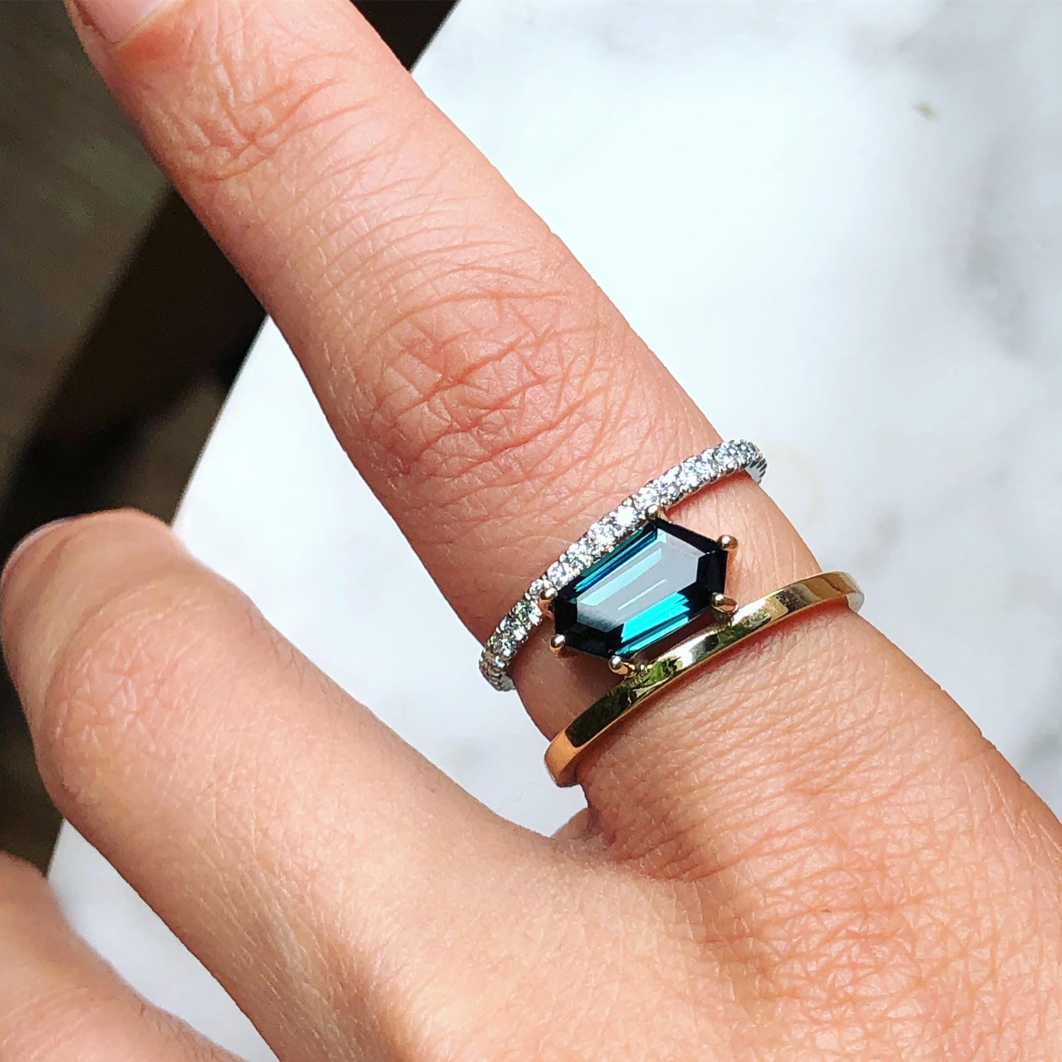 SELIN KENT's stunning Petra Tourmaline Ring features a custom-cut hexagonal blue tourmaline, flanked on two sides by two gold bands that connect in the back for a comfortable fit. 

- Tourmaline is approximately 2 carats and white diamonds are 0.40