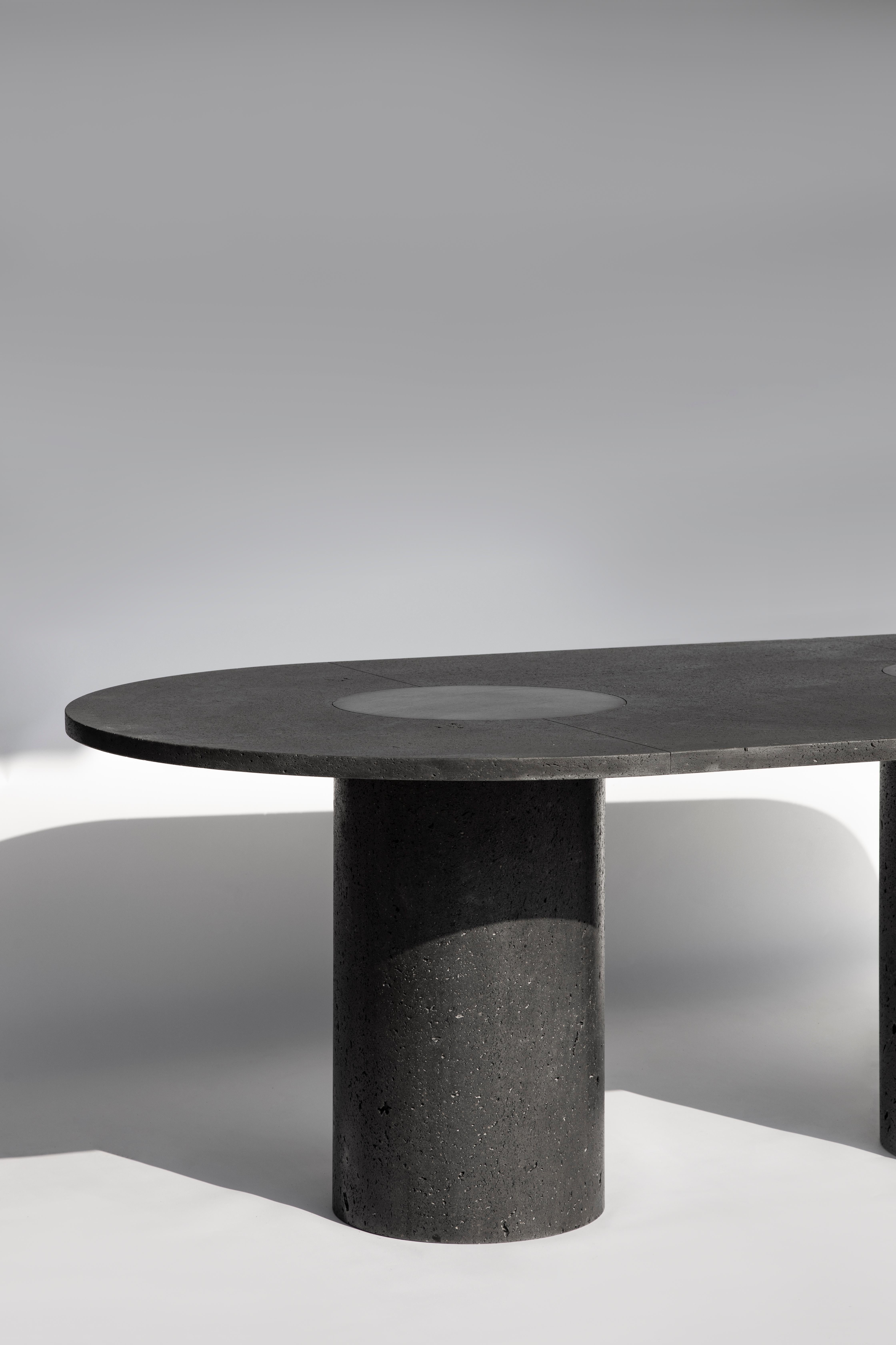 Nuestra reverencia hacia la suntuosidad de la piedra volcánica nos ha llevado a honrar este noble material con una mesa/escultura cuyo rico y poroso tablero se asienta sobre tres monolitos cilíndricos nacidos de los caprichos del terreno volcánico