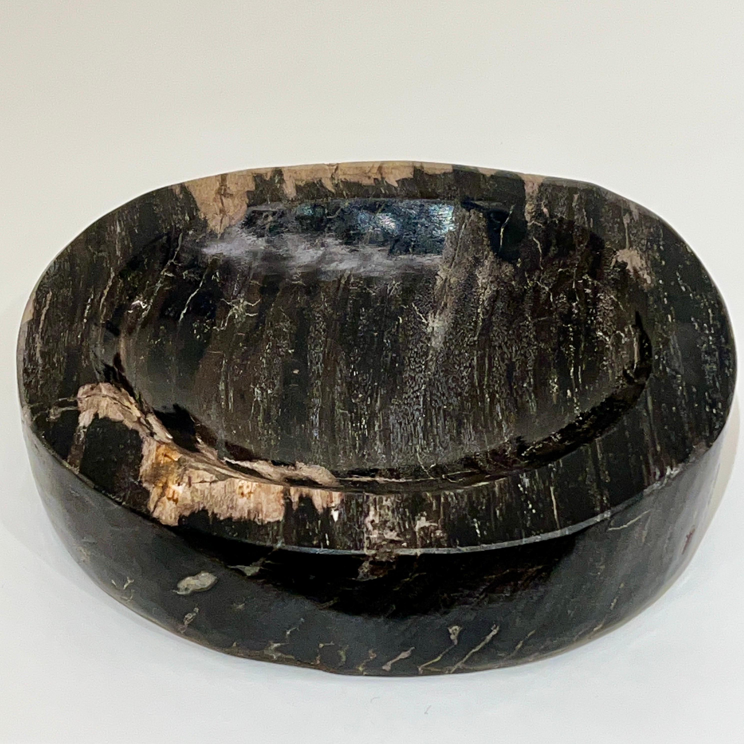 Petrified wood bowl naturally fossilized throughout thousands of years. These rare pieces have been hand cut and feature the highest quality petrified wood with polished centers and edges. Features unique coloration with natural stripes and spots in