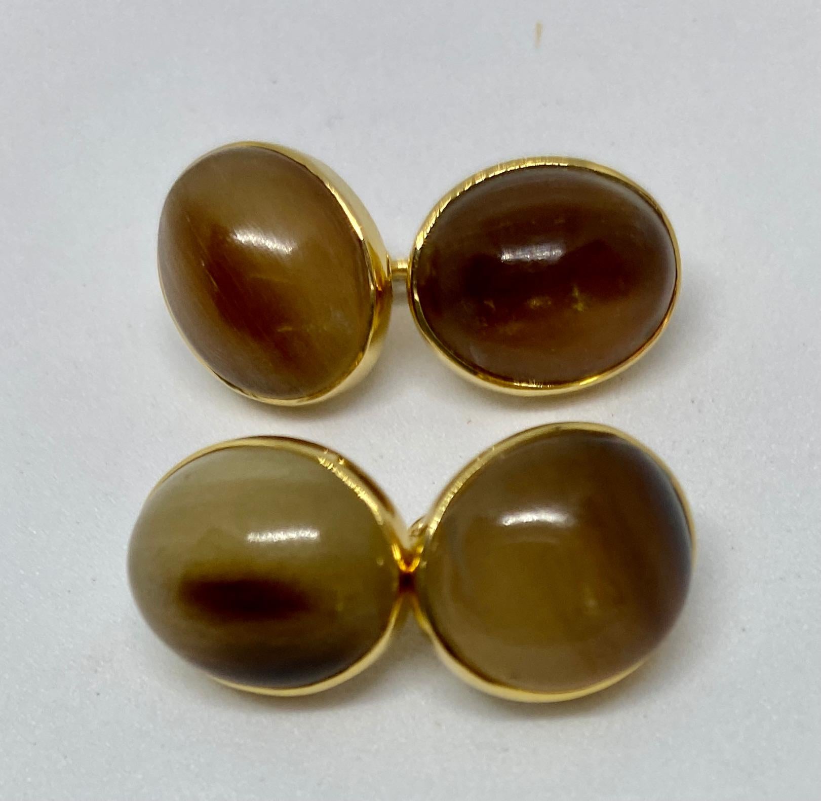 Extremely rare cufflinks featuring four cabochon-cut, agatized (petrified) wood ovals set in 18K yellow gold by Trianon.

The four ovals each measure 12.5 by 10.8mm and are linked to their mates by solid gold chains. They show various browns, tans