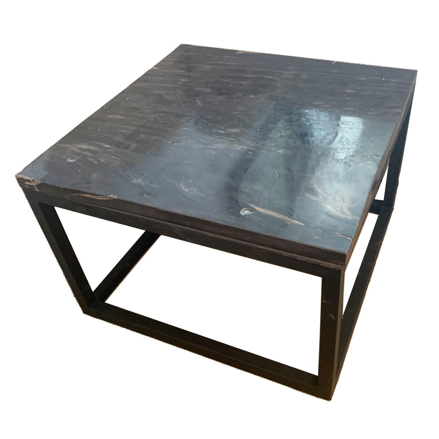 A polished petrified wood side table with a unique and natural design. The custom slice was cut to create a square slab where the the unique qualities of the wood are visible from all sides.