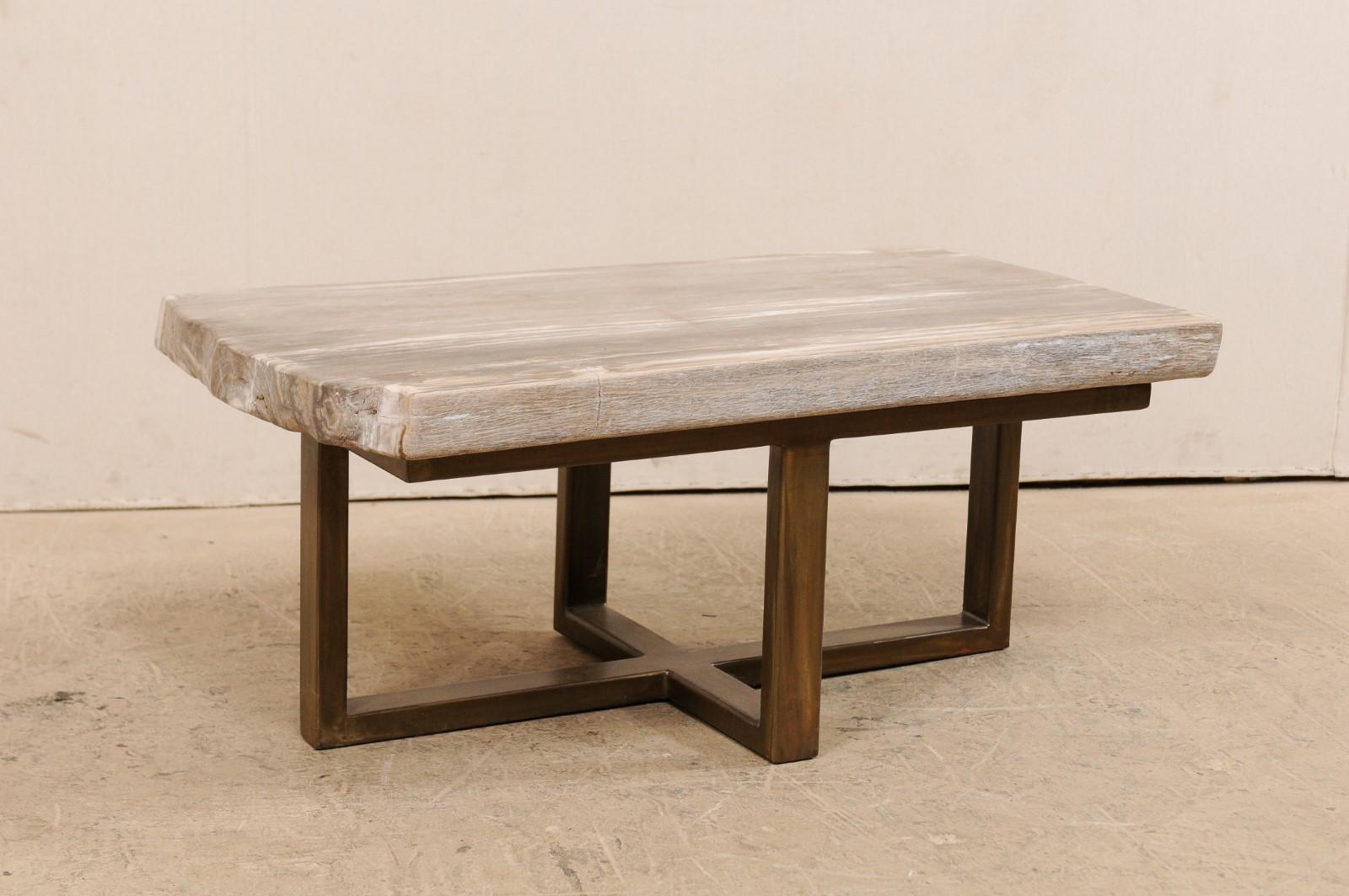 Ein modern gestalteter Couchtisch mit versteinerter Holzplatte (kann auch als Sitzbank verwendet werden). Dieser maßgefertigte Couchtisch wurde aus einer einzelnen dicken Platte aus glatt poliertem versteinertem Holz gefertigt und hat eine