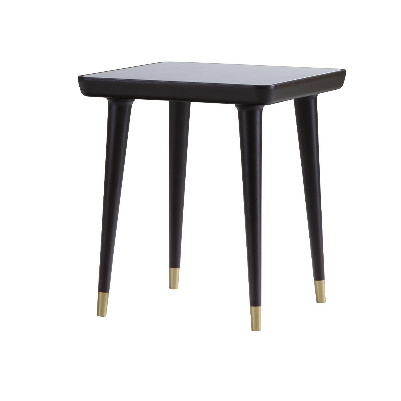Mid-century elegance coupled with contemporary details define this superb side table. The sleek design is raised on tapered legs and its overall structure in dark-brown-finished walnut lends it visual depth. Satin brass details enliven its feet,