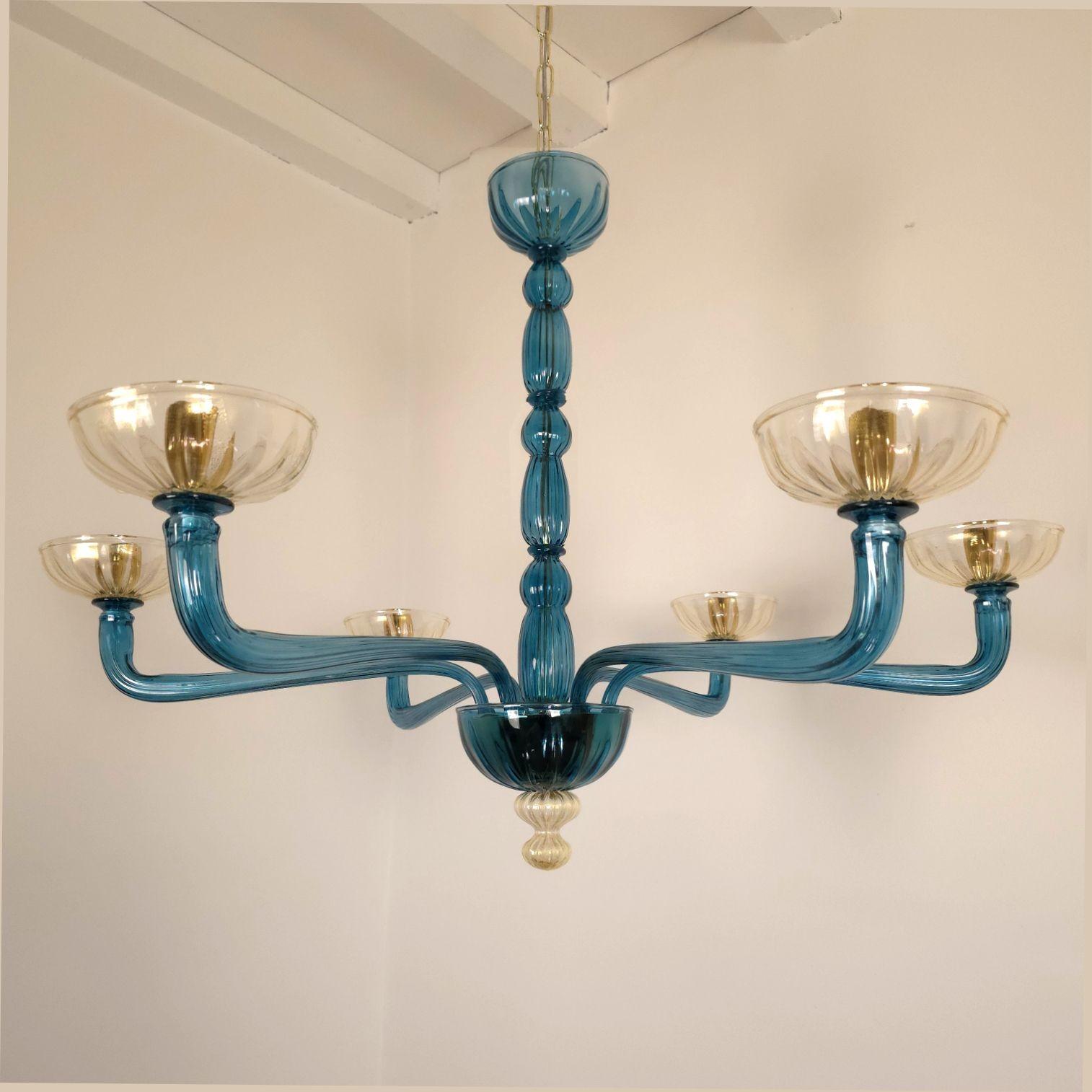 Lampadario Mid-Century Modern in vetro di Murano blu petrolio e oro chiaro, stile Venini, Italia anni '1980
Il lampadario in vetro di Murano in stile neoclassico ha sei luci e bracci.
Il lampadario è realizzato in vetro di Murano traslucido blu