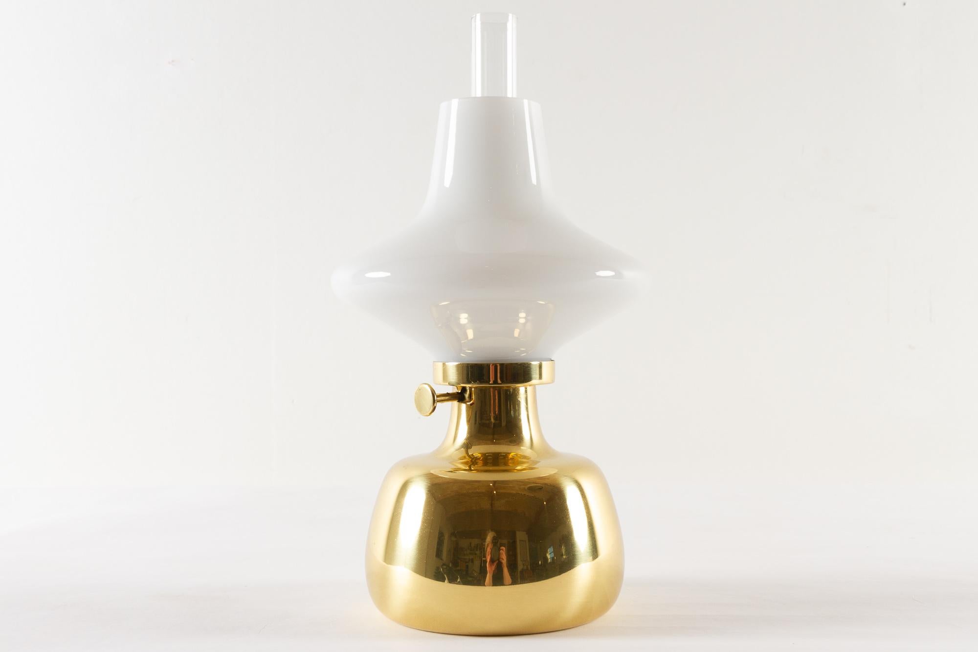 Petronella lamp by Henning Koppel for Louis Poulsen, 1960s.

Danish oil lamp in brass and white opaline glass. Designed by Danish designer Henning Koppel in 1961. The lamp body was handmade by Louis Poulsen in Denmark. The glass parts were made by