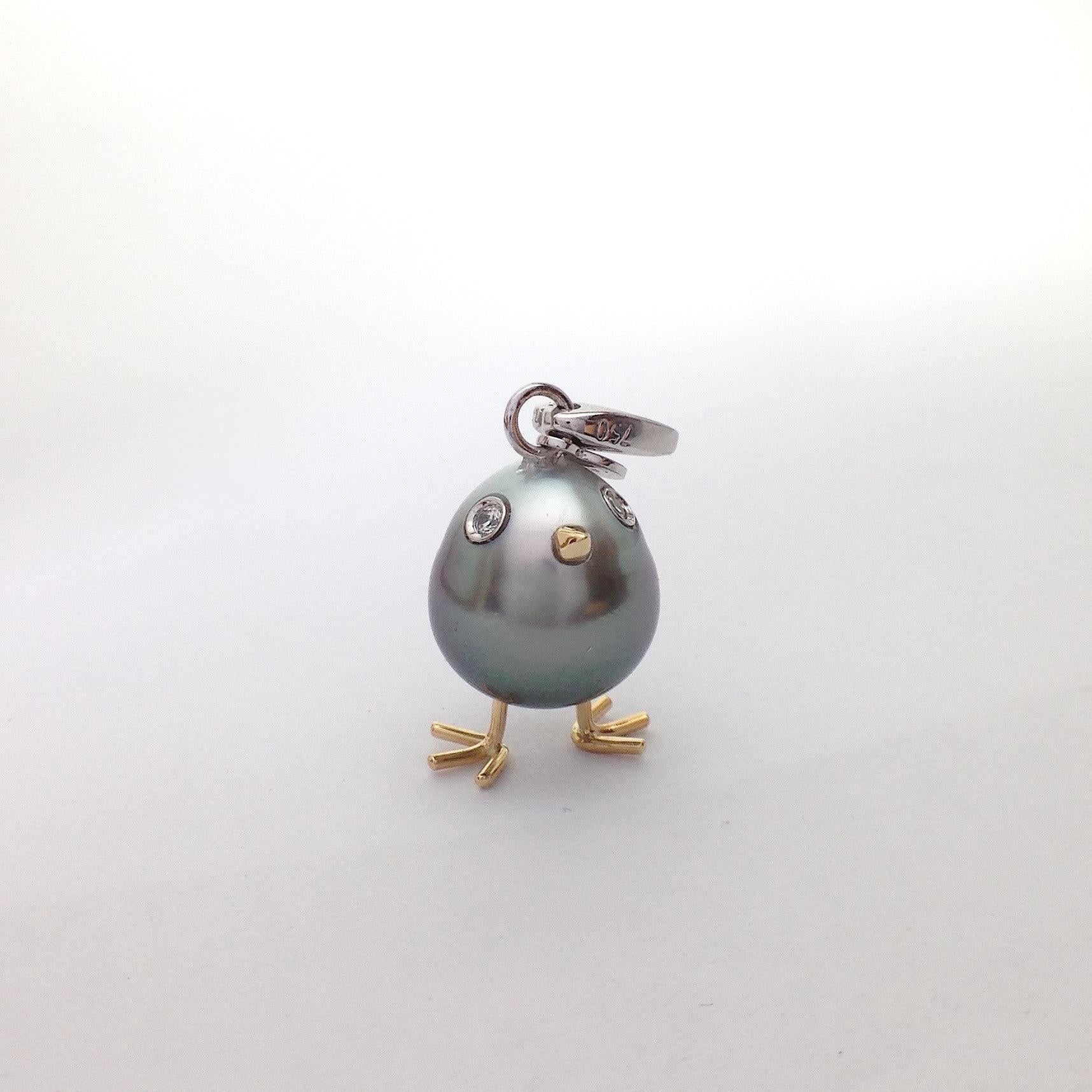 A Tahitian pearl has been carefully crafted to make a chick. He has his two legs, two eyes encrusted with two white diamonds and his beak. 
The gold is white for the eyes and the carabiner, for the other particulars it's yellow.
The caliber is ct