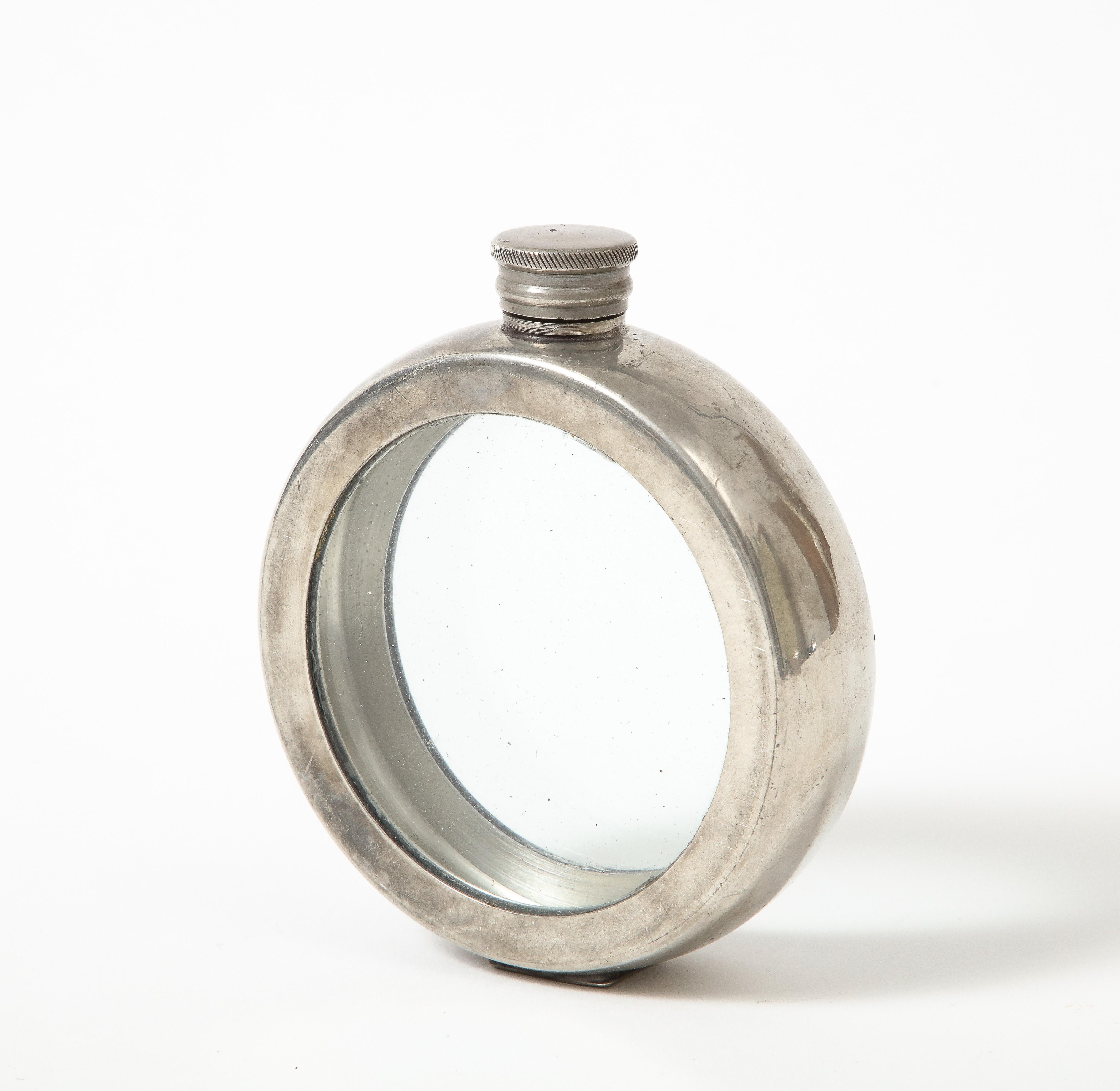 This  captivating object would be beautiful on a shelf.; smooth, reflective pewter wraps around a glass container. .