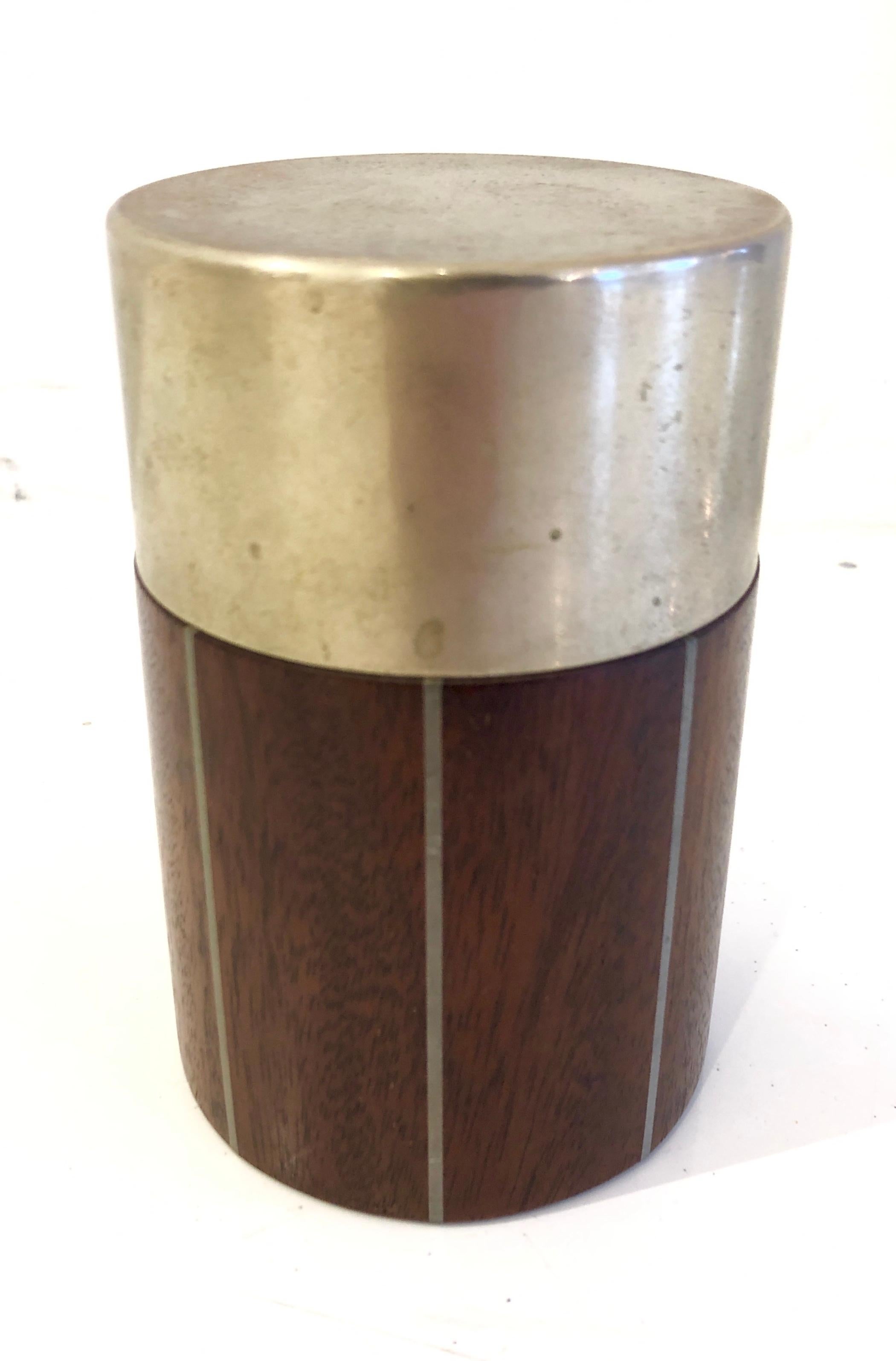 Small canister box of solid cuban mahogany with incised pewter bands and pewter lid. Paul Evans studio label to underside.