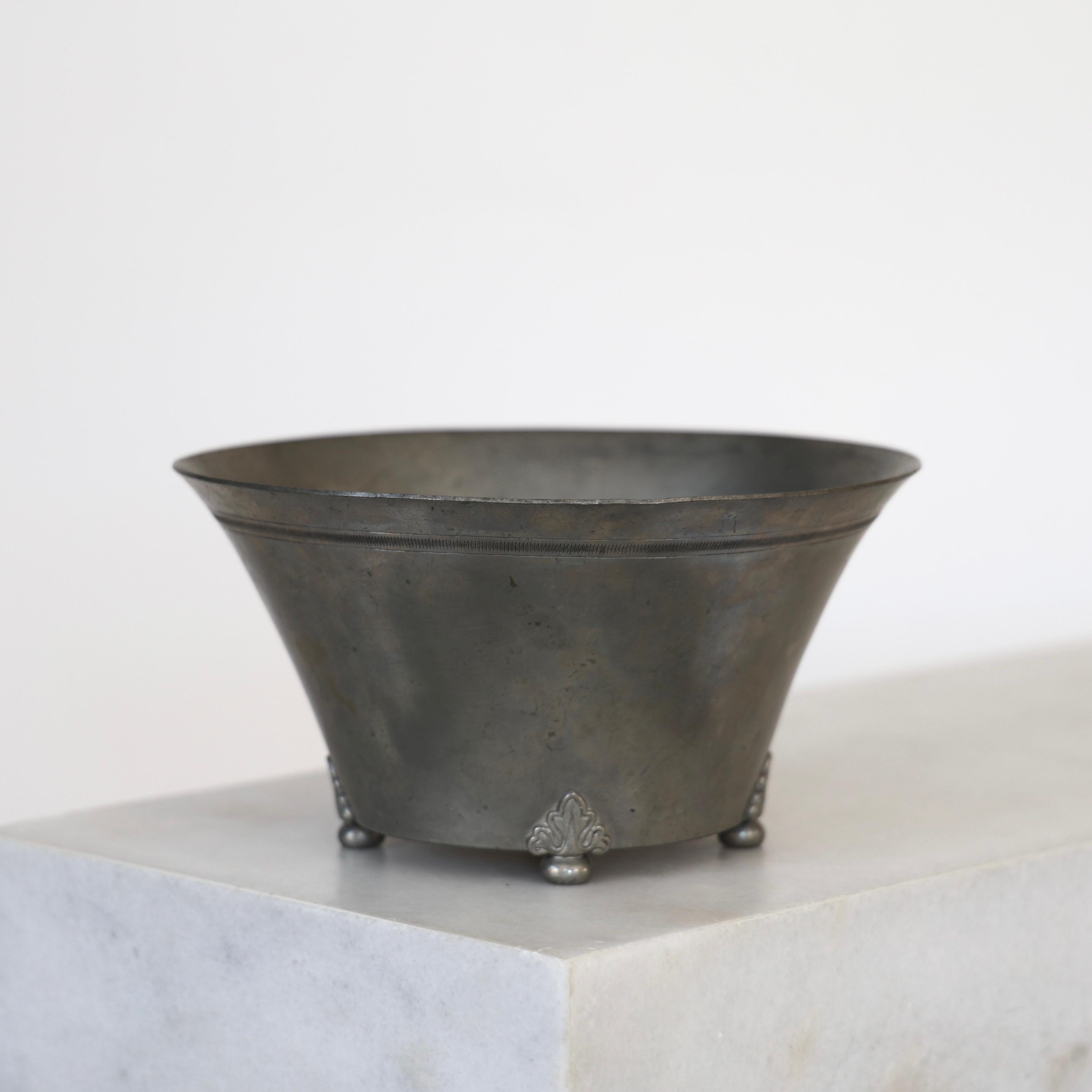 Pewter Bowl made by Just Andersen in 1930. An exquisite piece for a beautiful table.

* A round pewter bowl on feet with flora ornaments
* Designer: Just Andersen
* Style: 8
* Manufacturer: GAB Guldmedsaktiebolag
* Year: 1930
* Condition: Fair