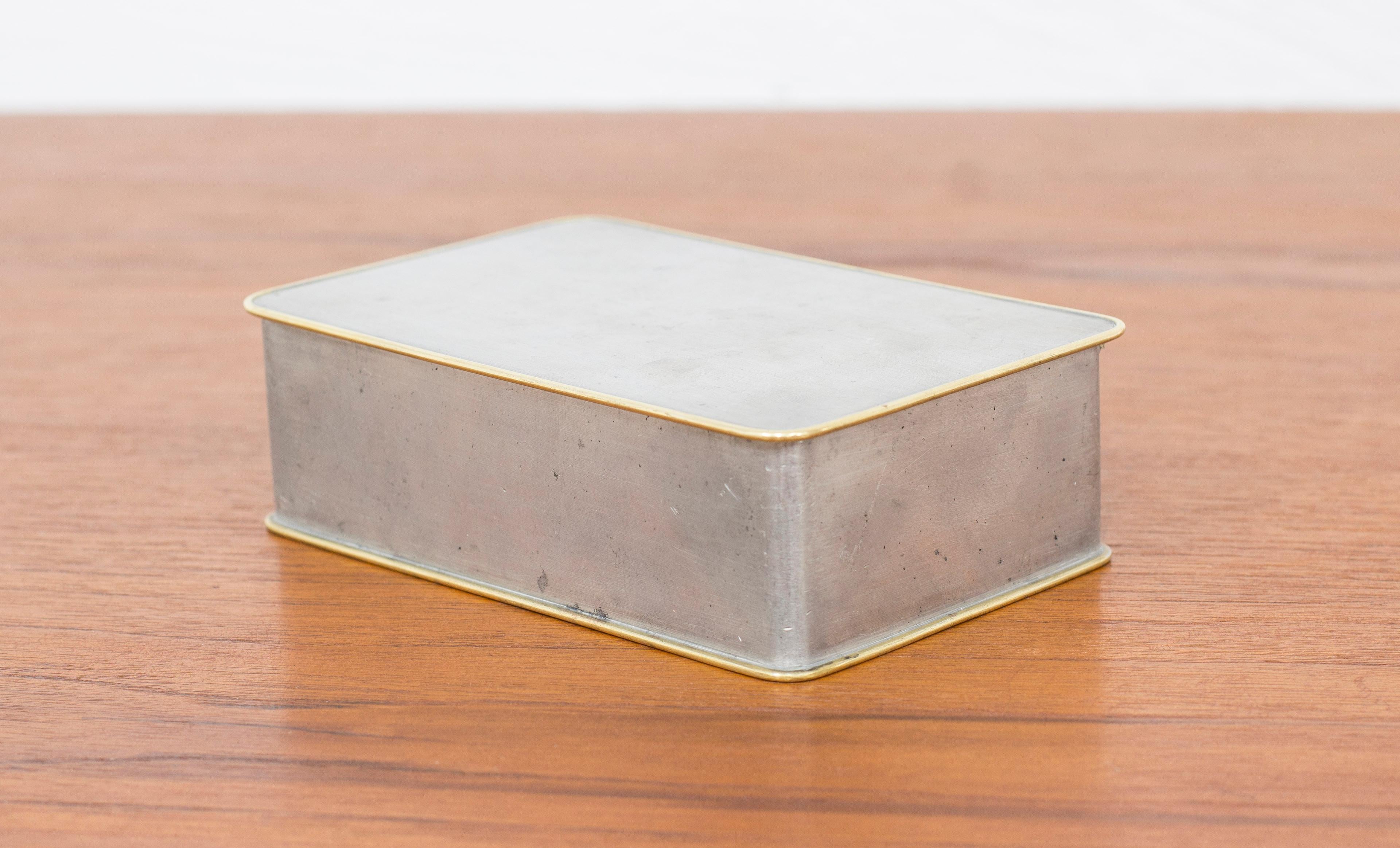 Box designed by Nils Fougstedt. Produced by Firma Svenskt Tenn, this example made in 1953. Made from pewter with brass edges. Good vintage condition with age related patina and wear.



Designer: Nils Fougstedt

Manufacturer: Svenskt