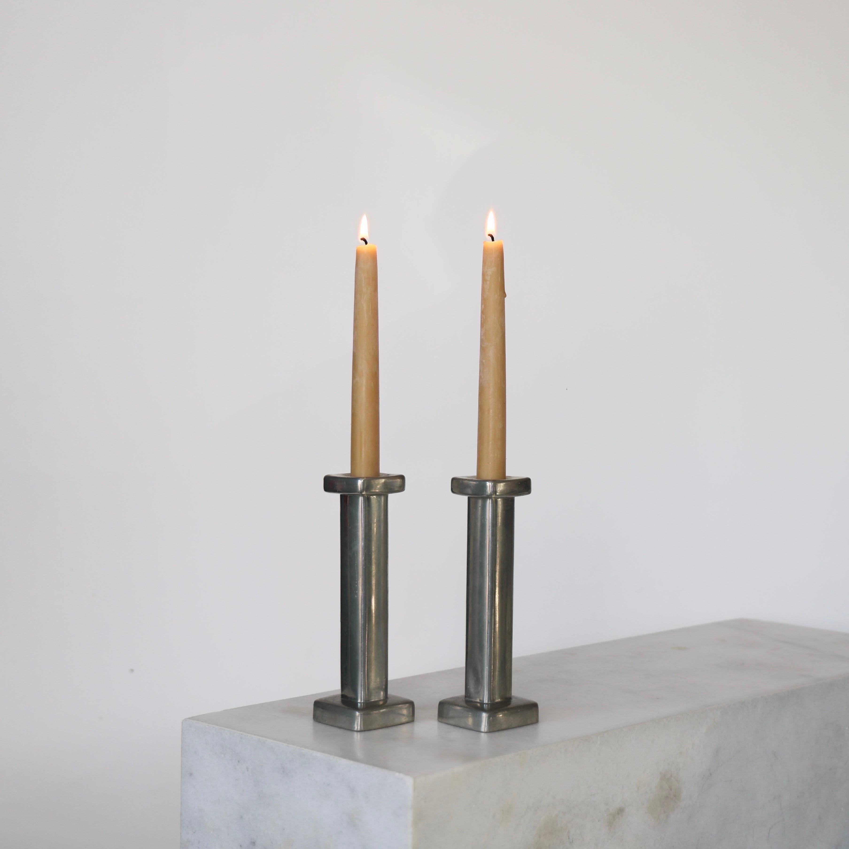 Set of Pewter Candle Holders designed by Astrid Fog for Just Andersen in the 1970s. An impressive set for a beautiful table. 

* Pair (2) of square pewter candlestick holders
* Designer: Astrid Fog
* Style:573045 AF
* Manufacturer: Just Andersen
*