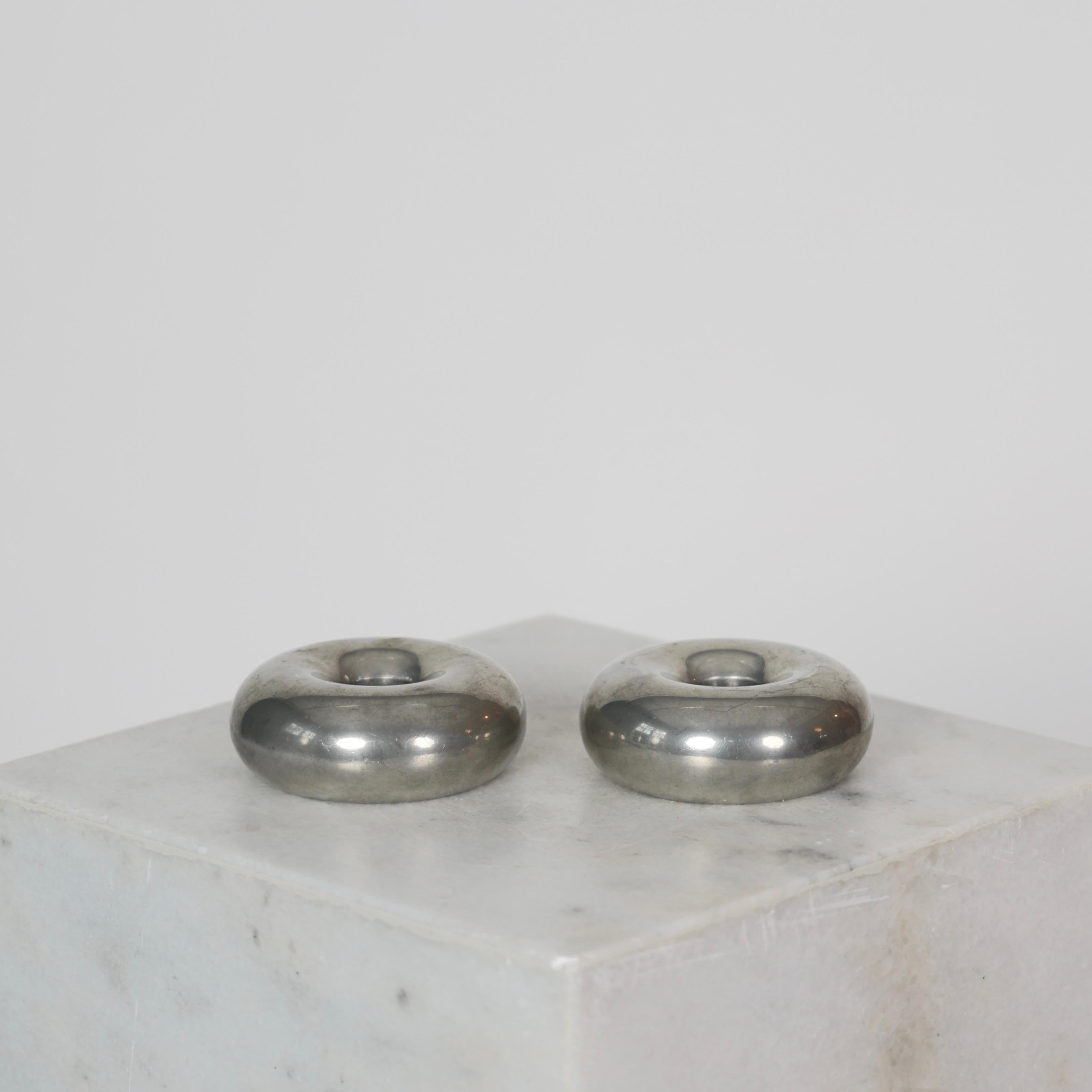 Set of Round Pewter Candlestick Holders designed by Astrid Fog for Just Andersen in the 1970s. 

* Pair (2) of small round pewter candlestick holders
* Designer: Astrid Fog
* Style: 573042 AF
* Manufacturer: Just Andersen
* Year: 1970s
* Condition: